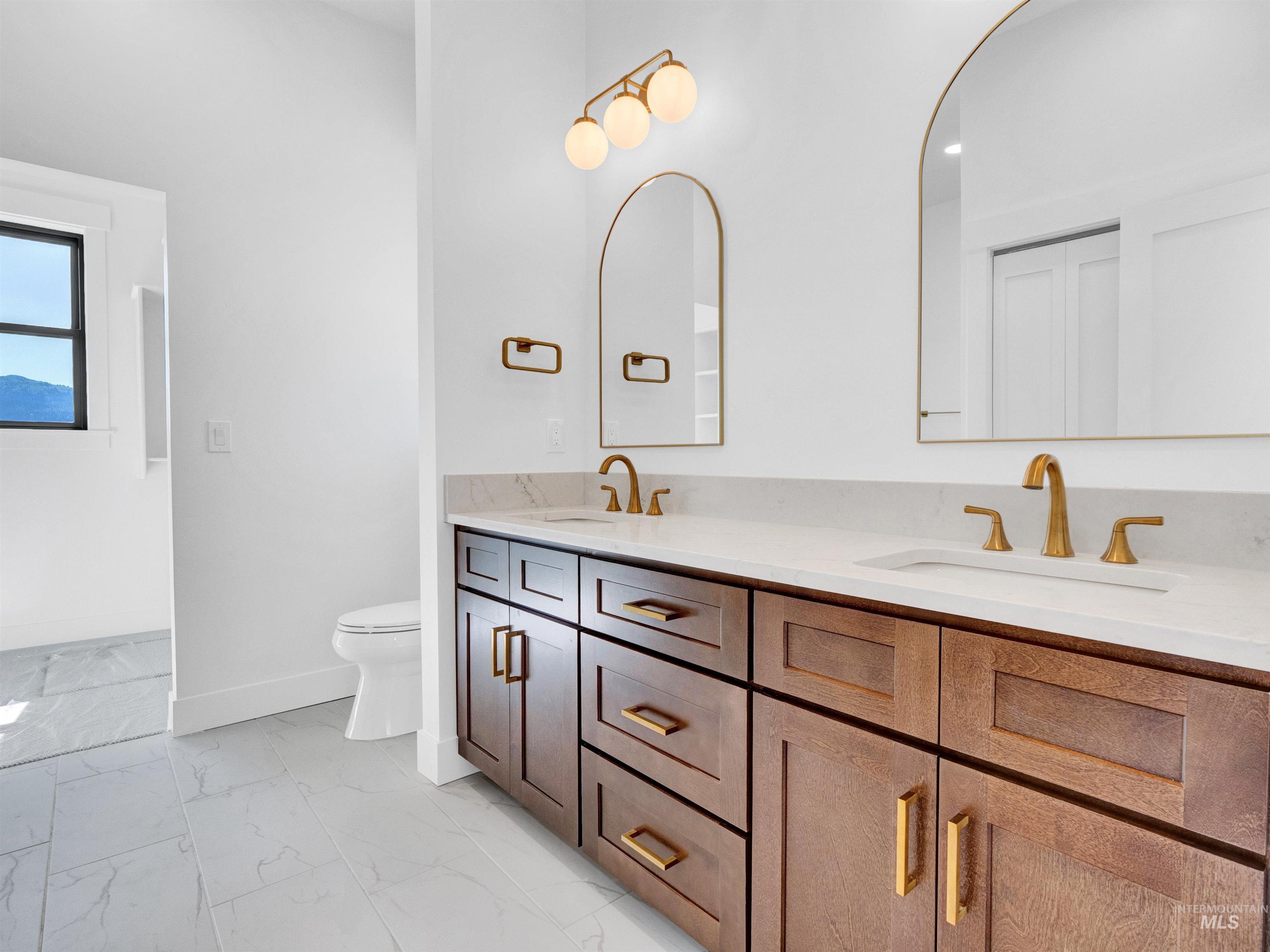 Bathroom featuring marble look tile flooring and double vanity