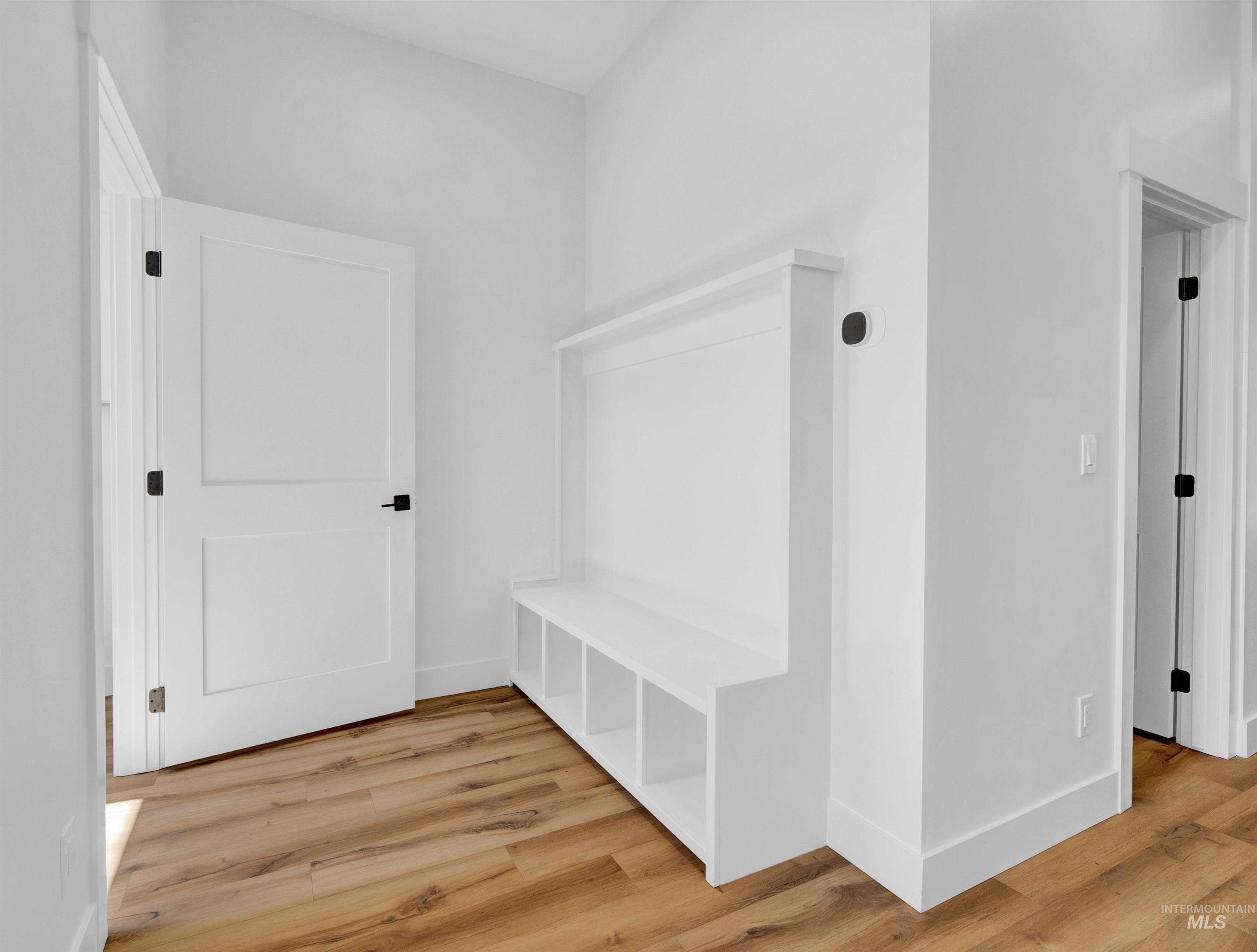 Mudroom featuring wood finished floors and baseboards