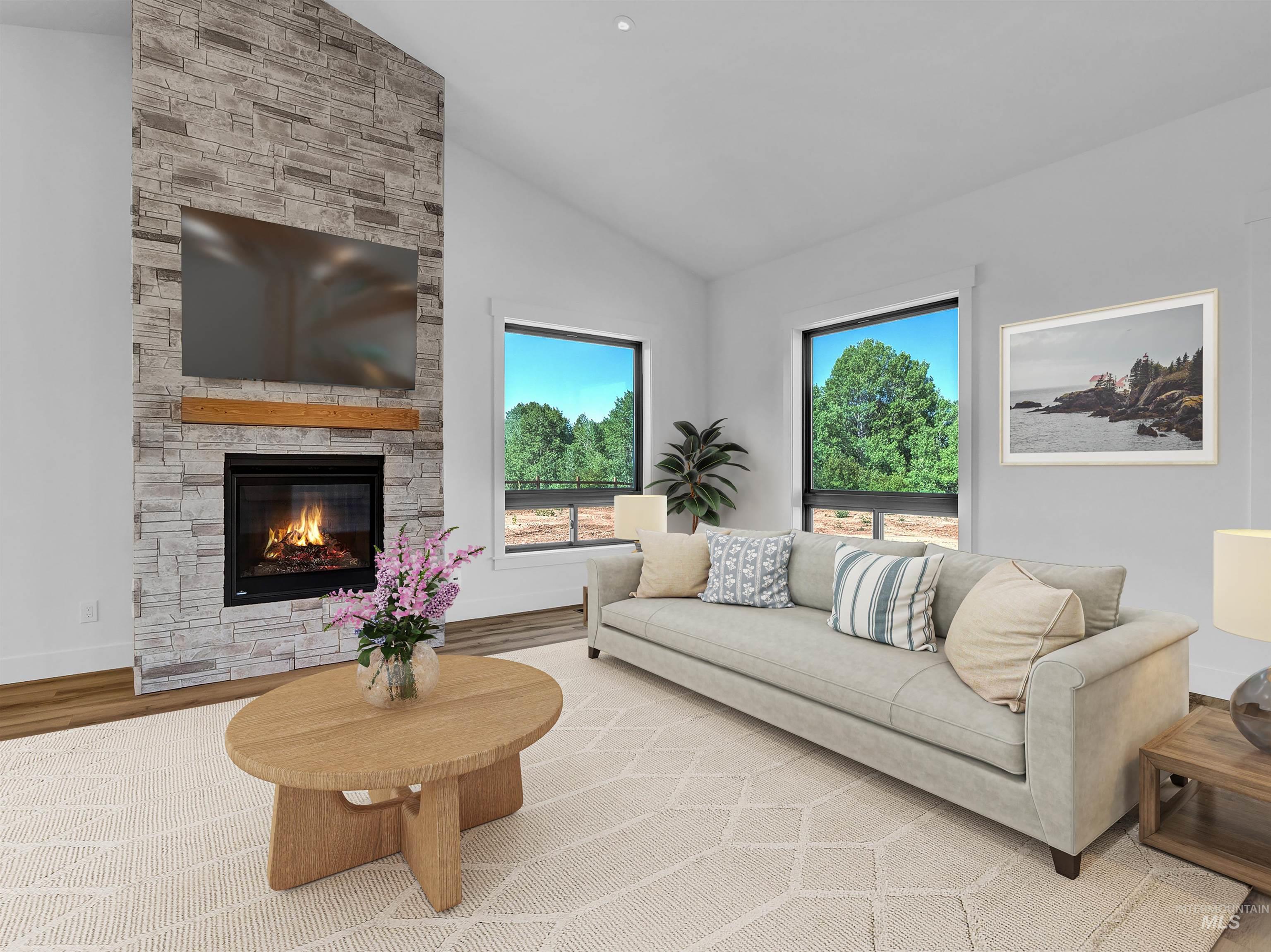 Living area with wood finished floors, a fireplace, and high vaulted ceiling