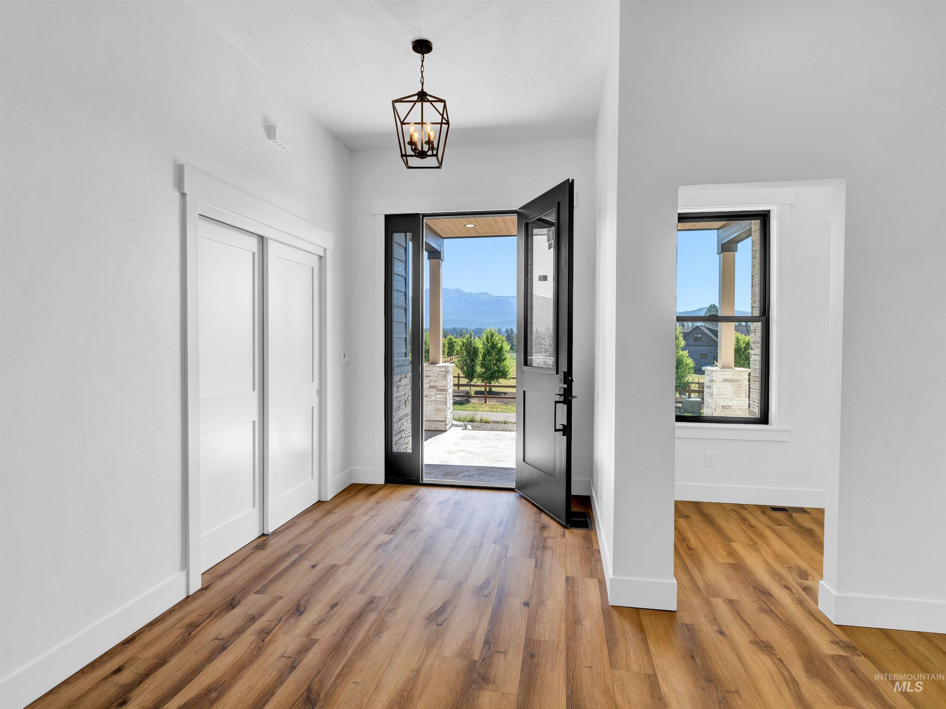 Entryway with wood finished floors and a chandelier