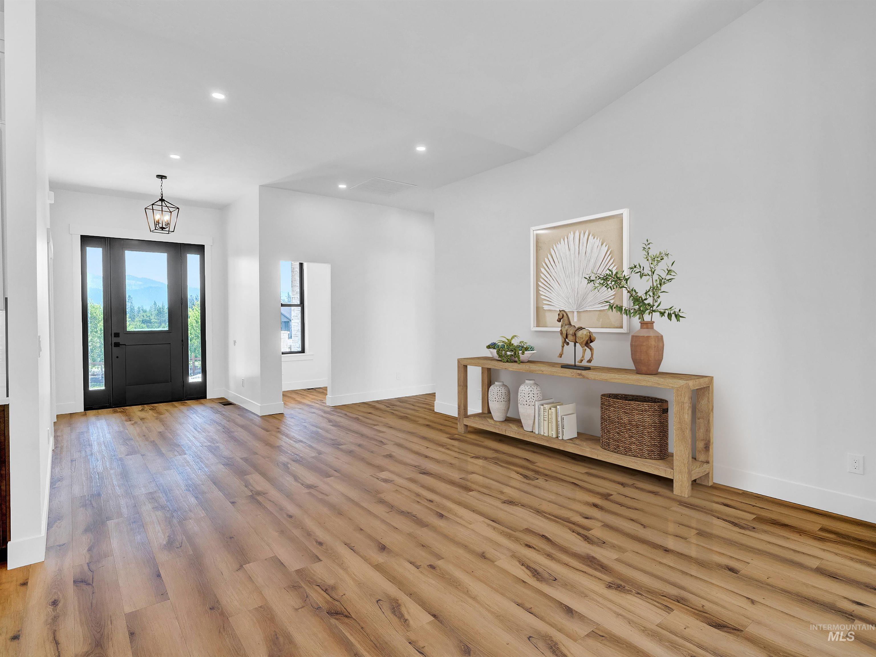 Foyer with light wood-type flooring, recessed lighting, and a chandelier
