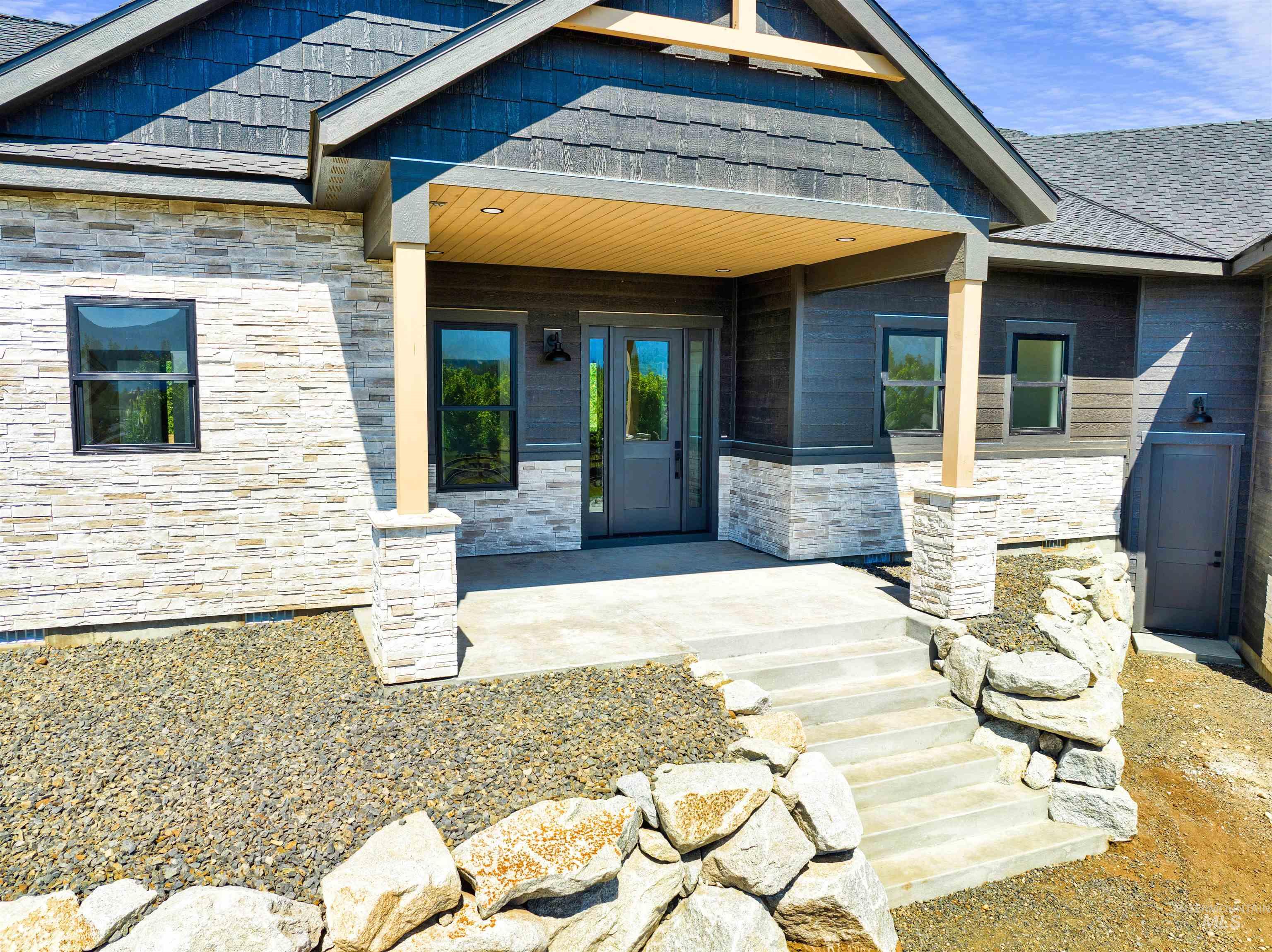 Property entrance featuring stone siding and a porch