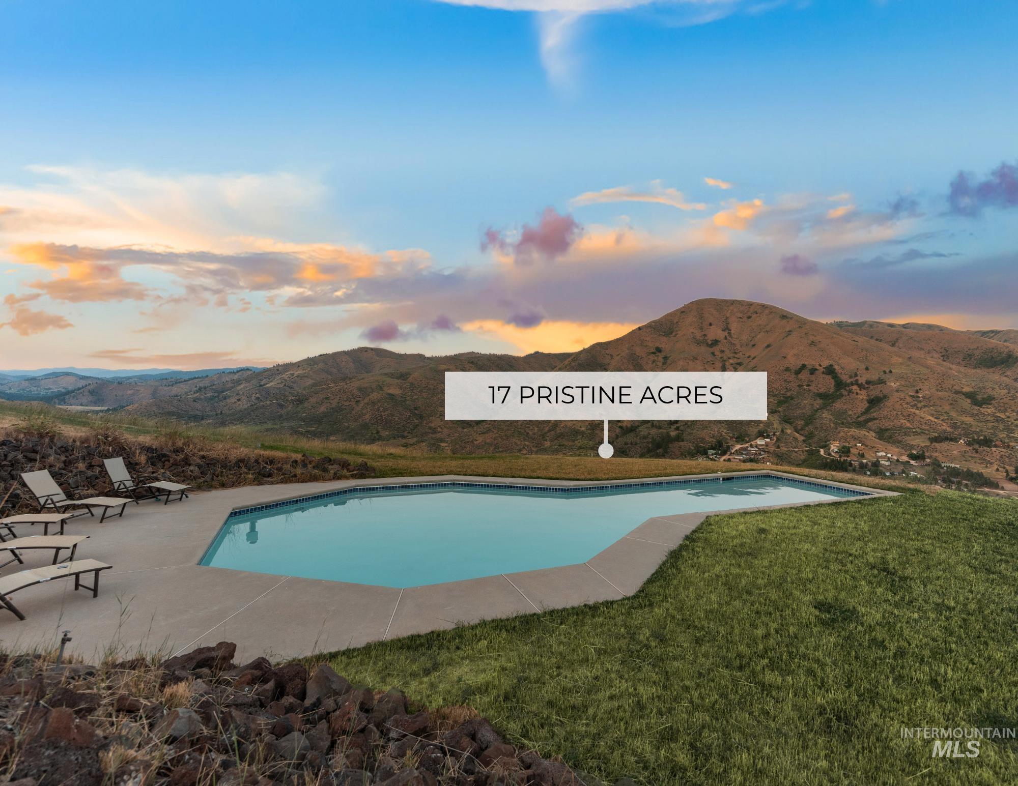 Pool at dusk featuring a mountain view, an outdoor pool, a lawn, and a patio