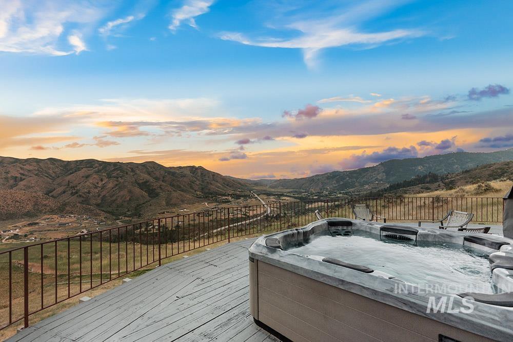 Deck with a hot tub and a mountain view