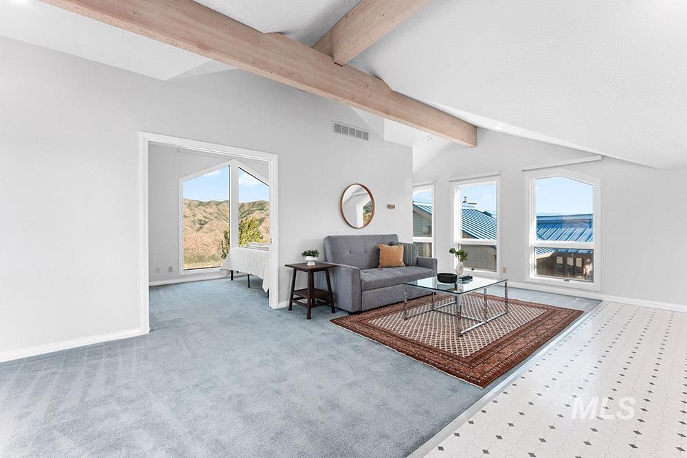 Carpeted living area with healthy amount of natural light