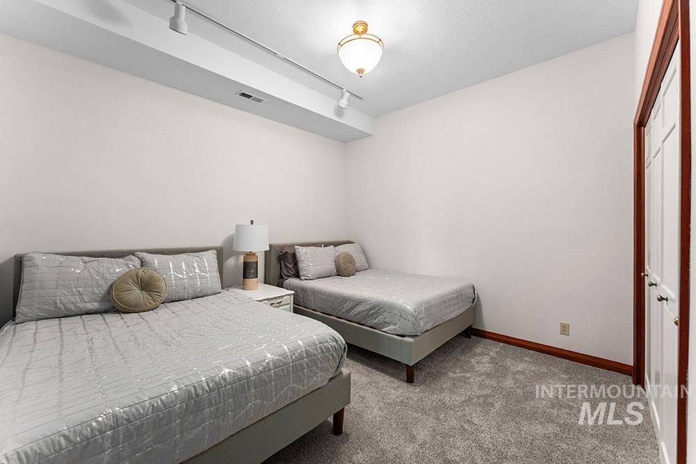 Bedroom featuring carpet floors and rail lighting