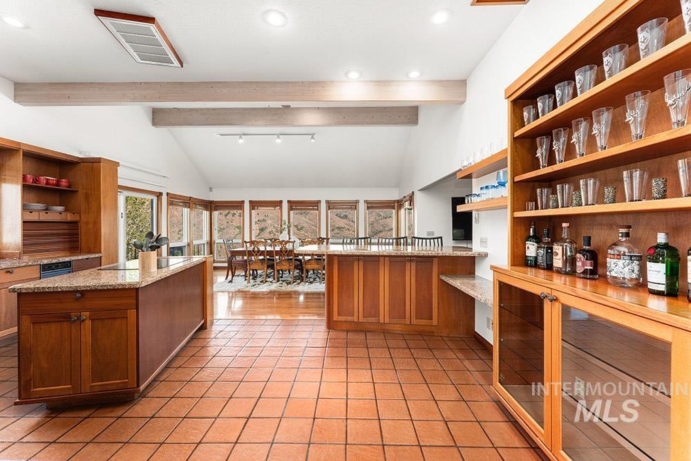 Kitchen featuring open shelves, light tile patterned floors, brown cabinetry, recessed lighting, and a peninsula