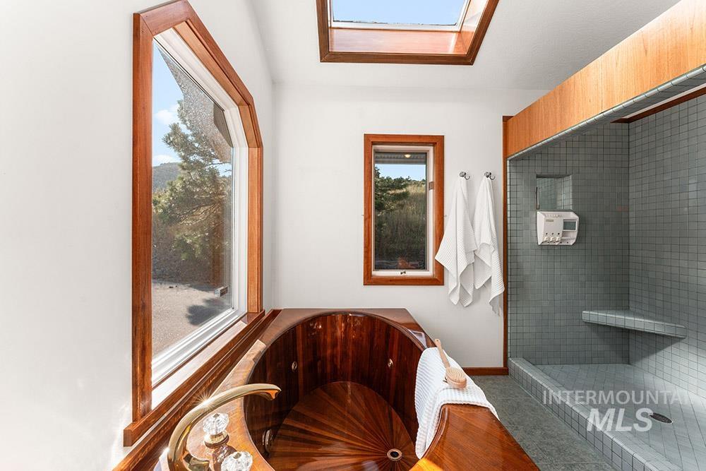 Full bathroom with a skylight, a tile shower, and a jetted tub