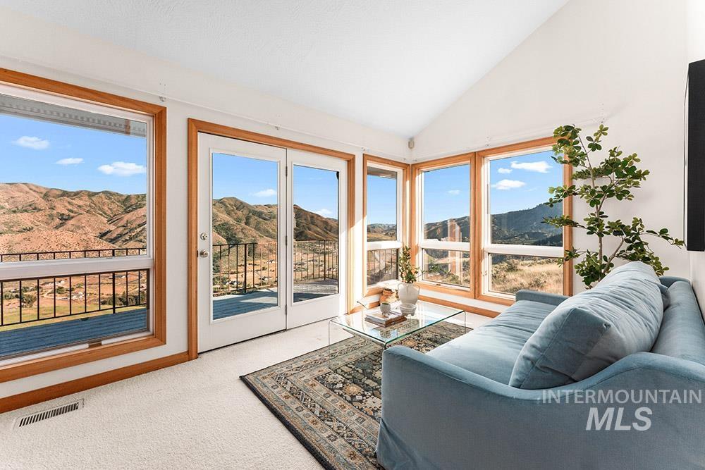 Living room featuring a mountain view, carpet floors, and lofted ceiling