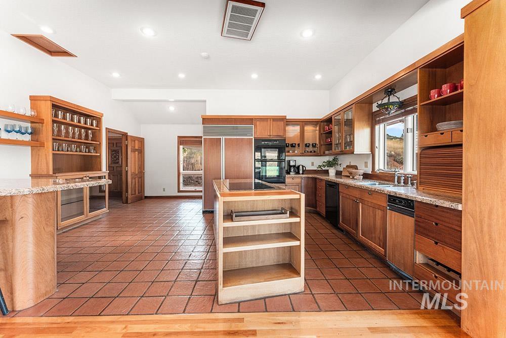 Kitchen with open shelves, healthy amount of natural light, a kitchen island, and recessed lighting