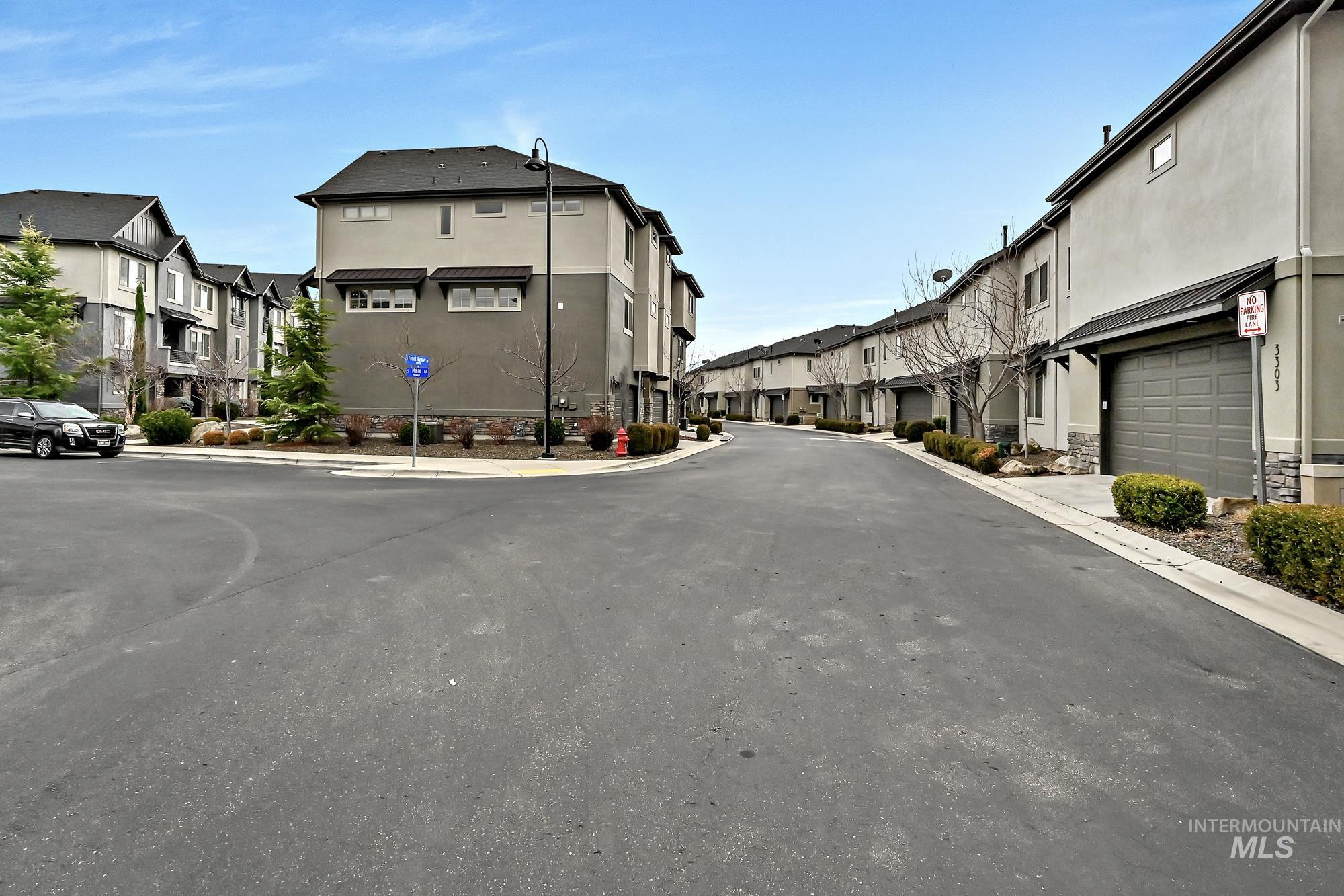 View of street parking for guests and a lane leading to the unit's two-car garage.
