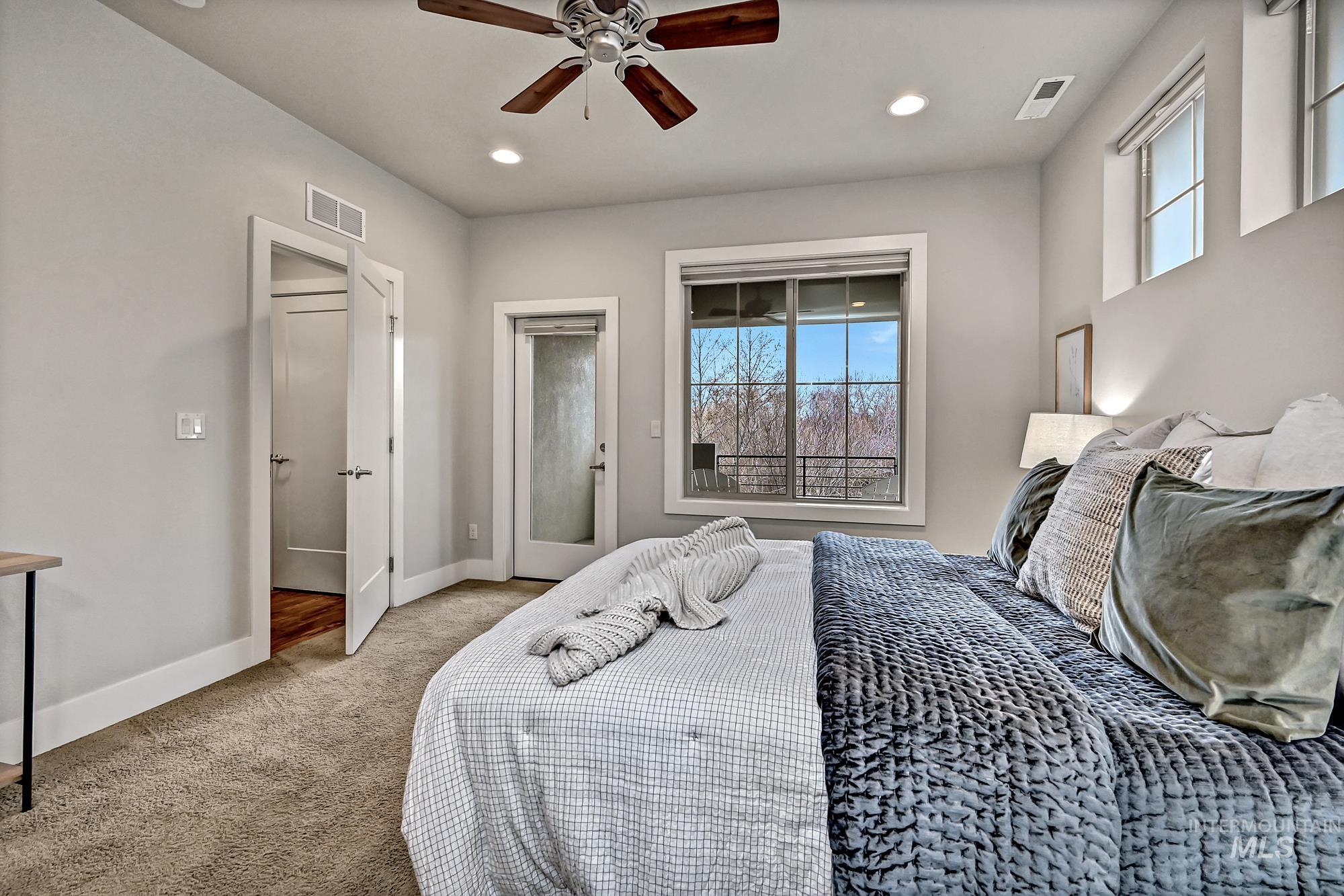 Carpeted bedroom featuring access to a private balcony, recessed lighting, a ceiling fan, and large windows