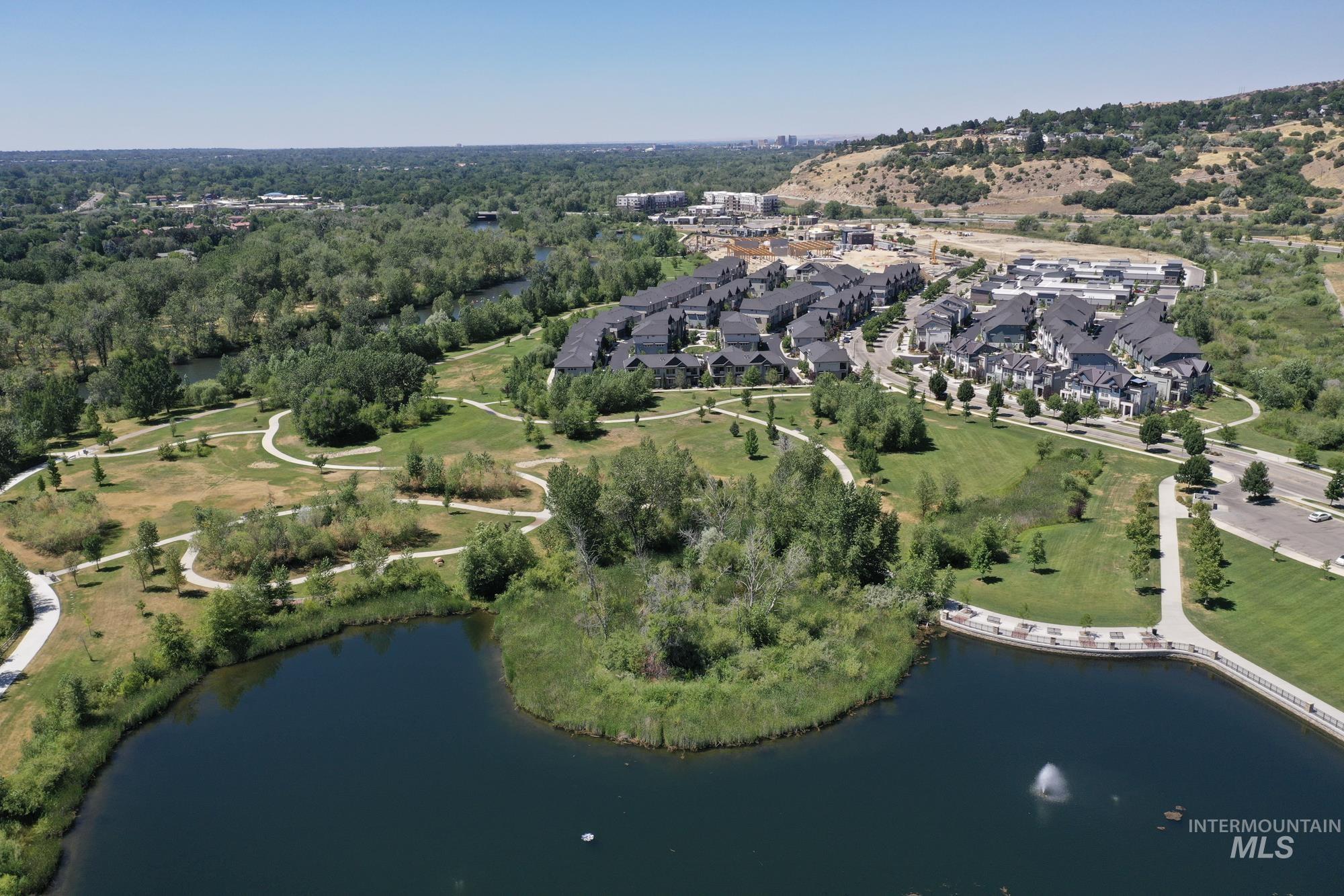 Aerial view of property and surrounding area featuring a large pond in Marianne Williams Park
