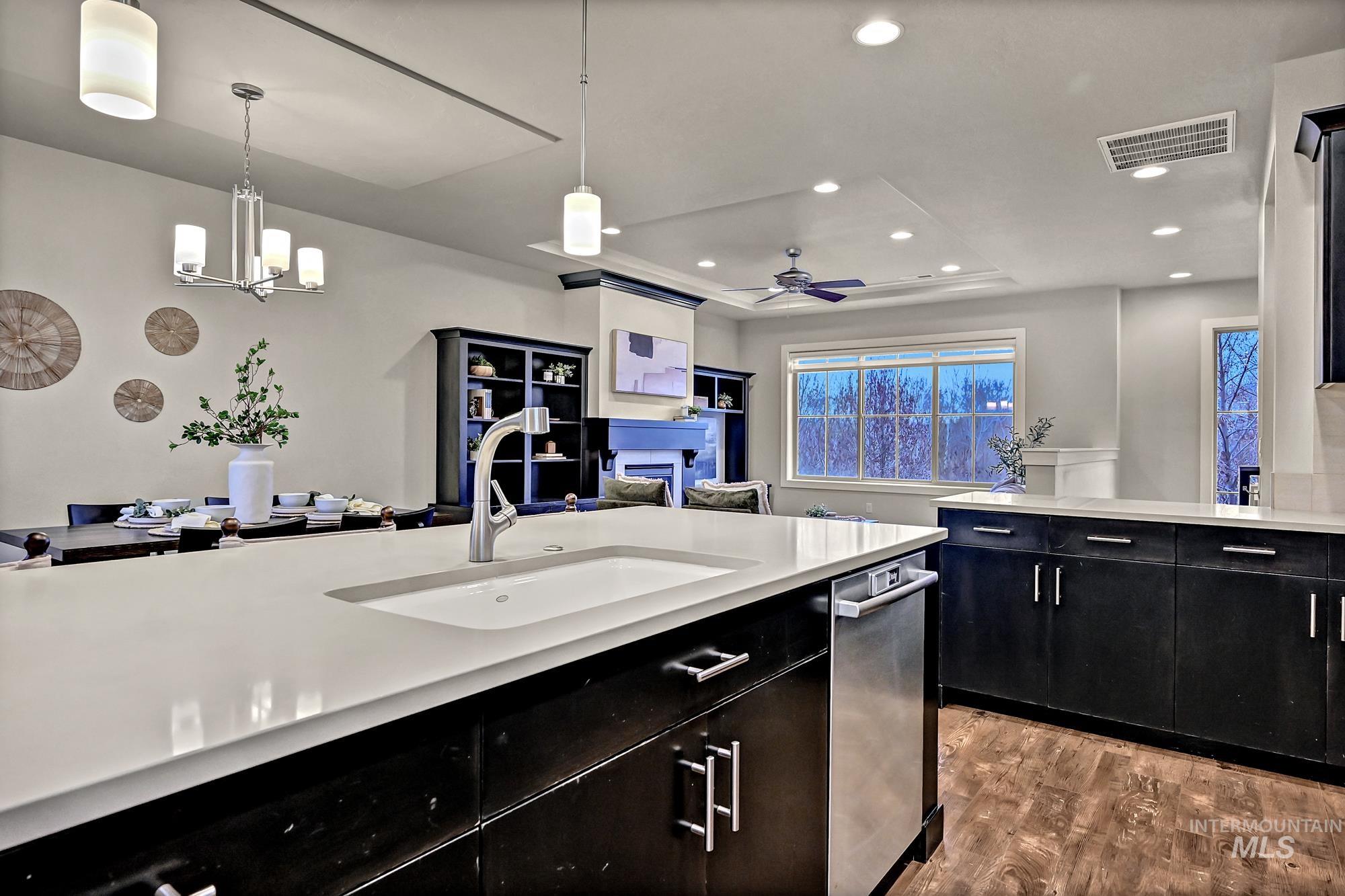 Kitchen featuring dark cabinetry, recessed lighting, decorative light fixtures, white quartz countertops, and an island