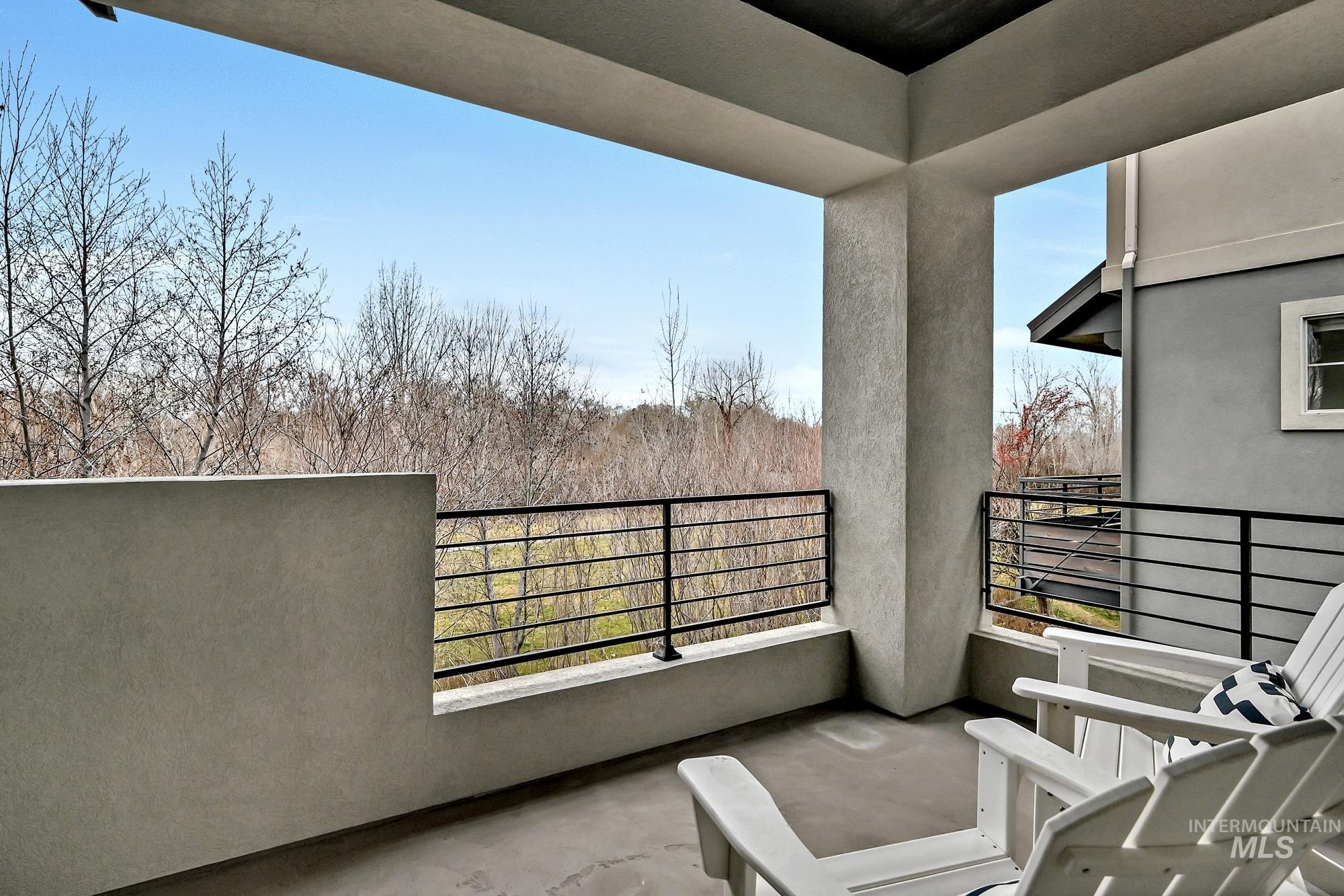 View from primary balcony of trees and the river in the distance.