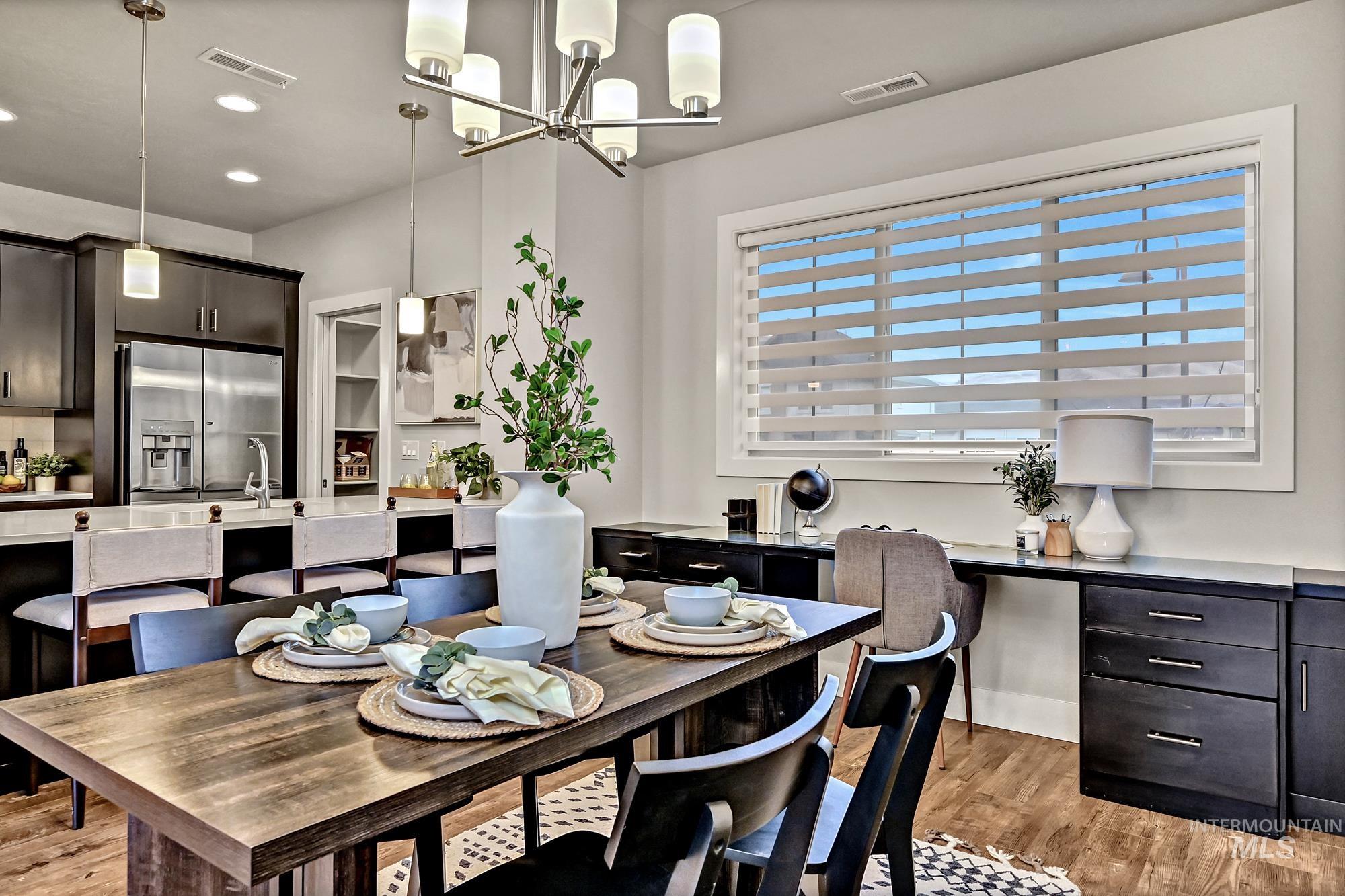 Dining area with a chandelier, wood finished floors, and recessed lighting