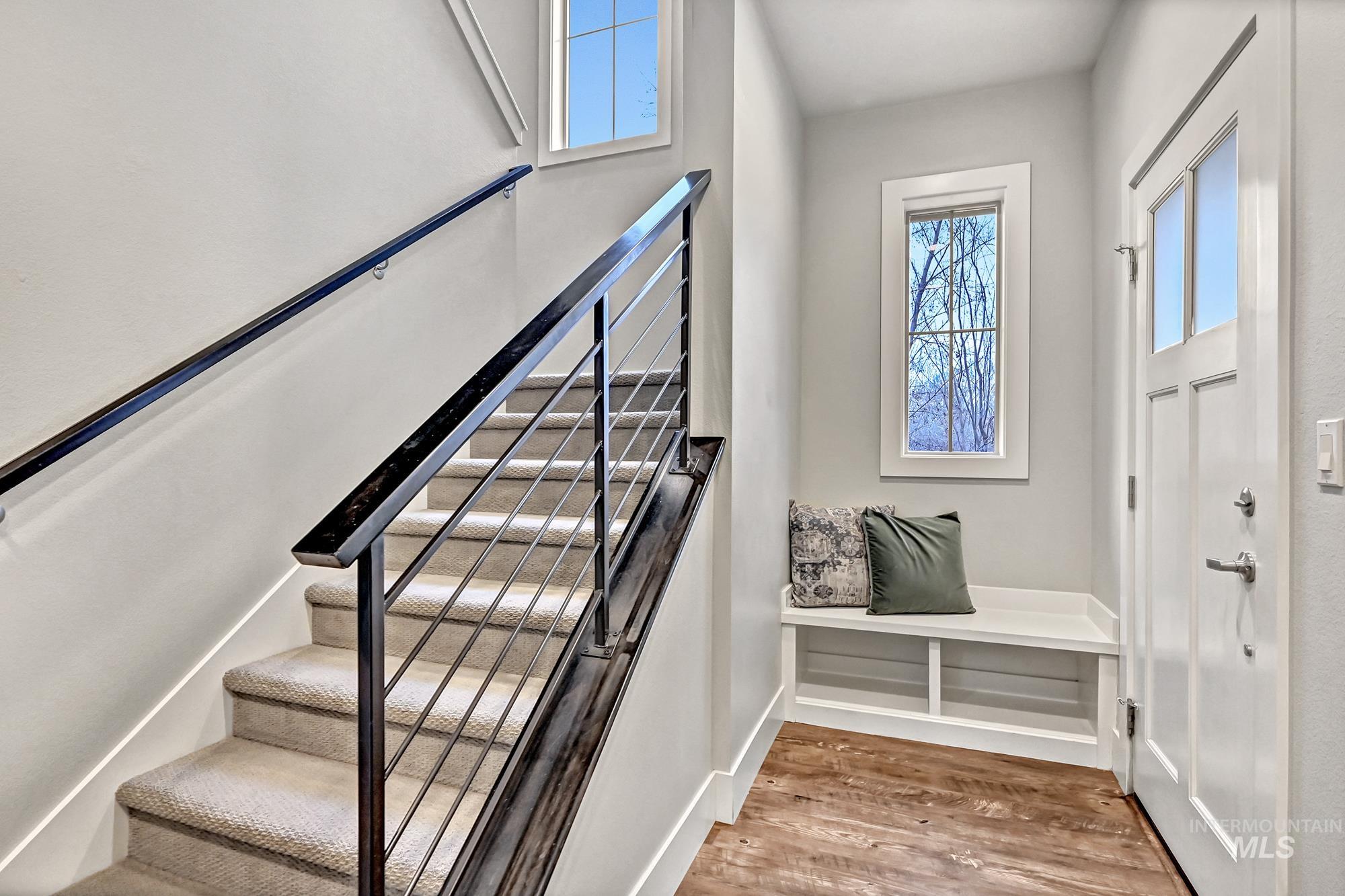 Main-level entry staircase with wood finished floors and a built-in bench with cubbies