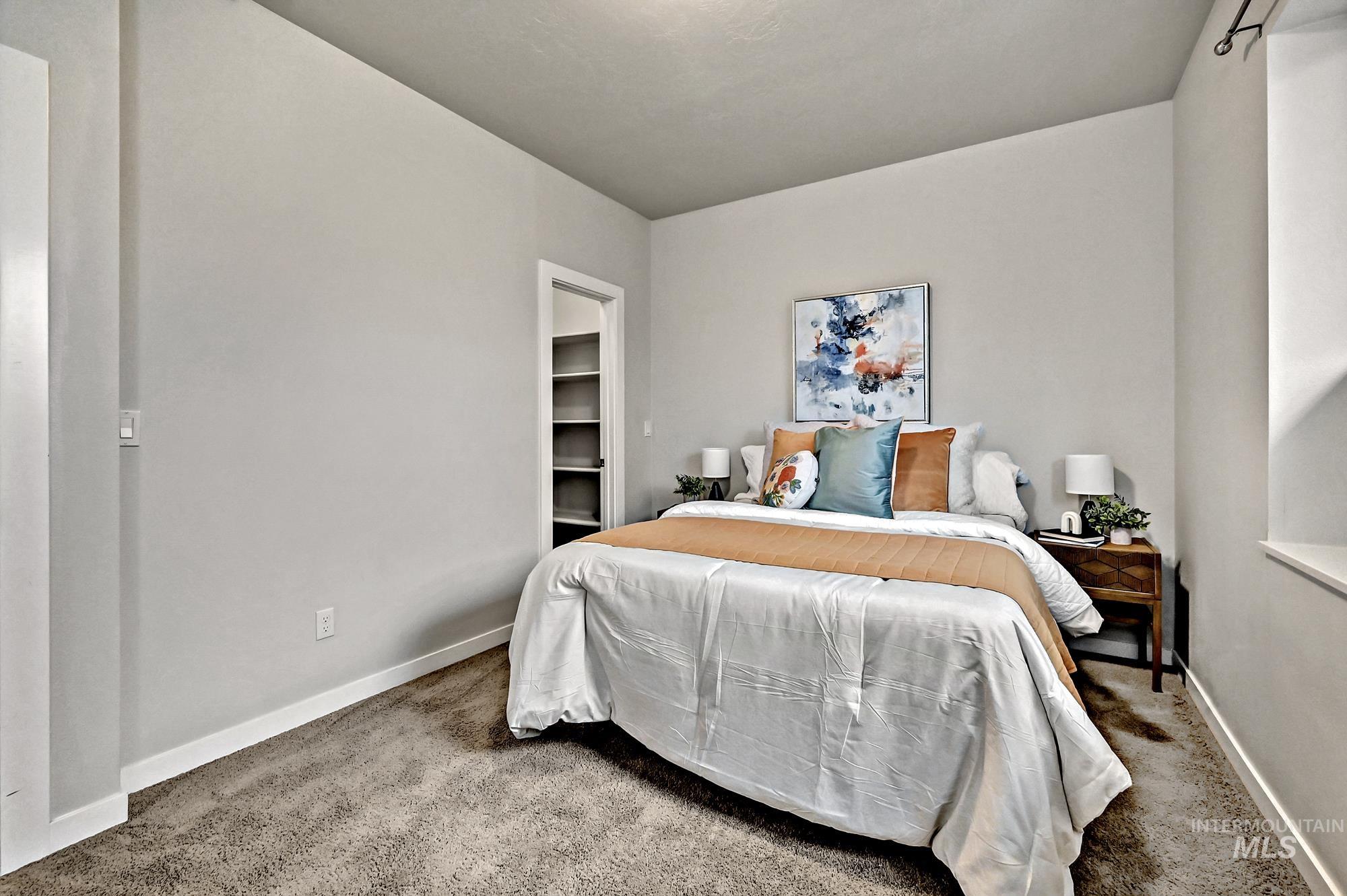 Carpeted bedroom with a spacious closet and window with a view of the Boise Greenbelt