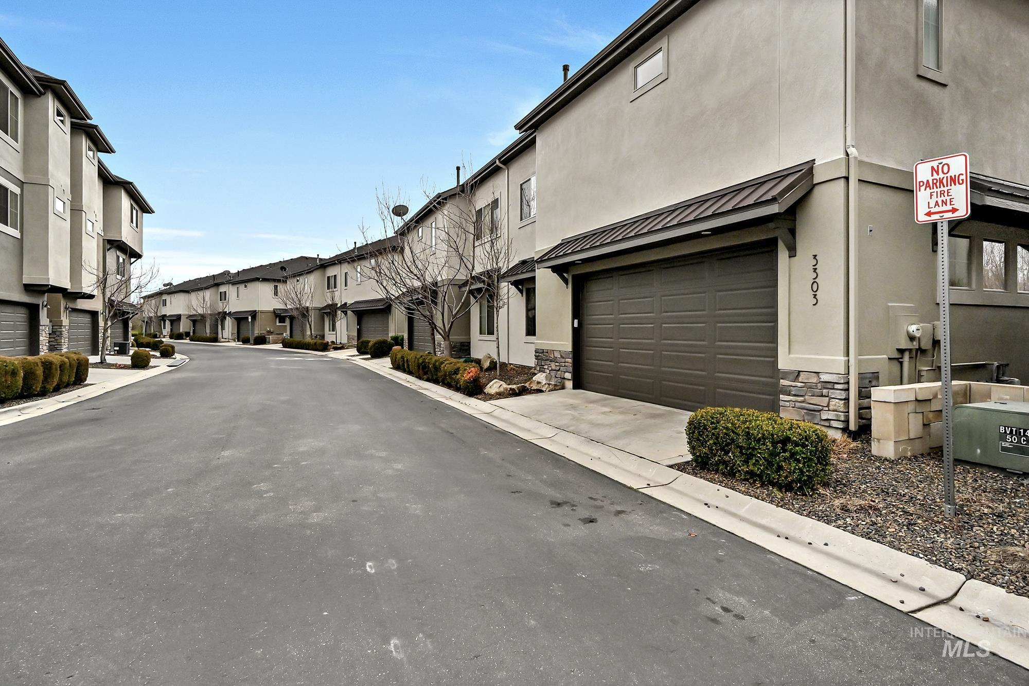 View of street parking for guests and a lane leading to the unit's two-car garage.