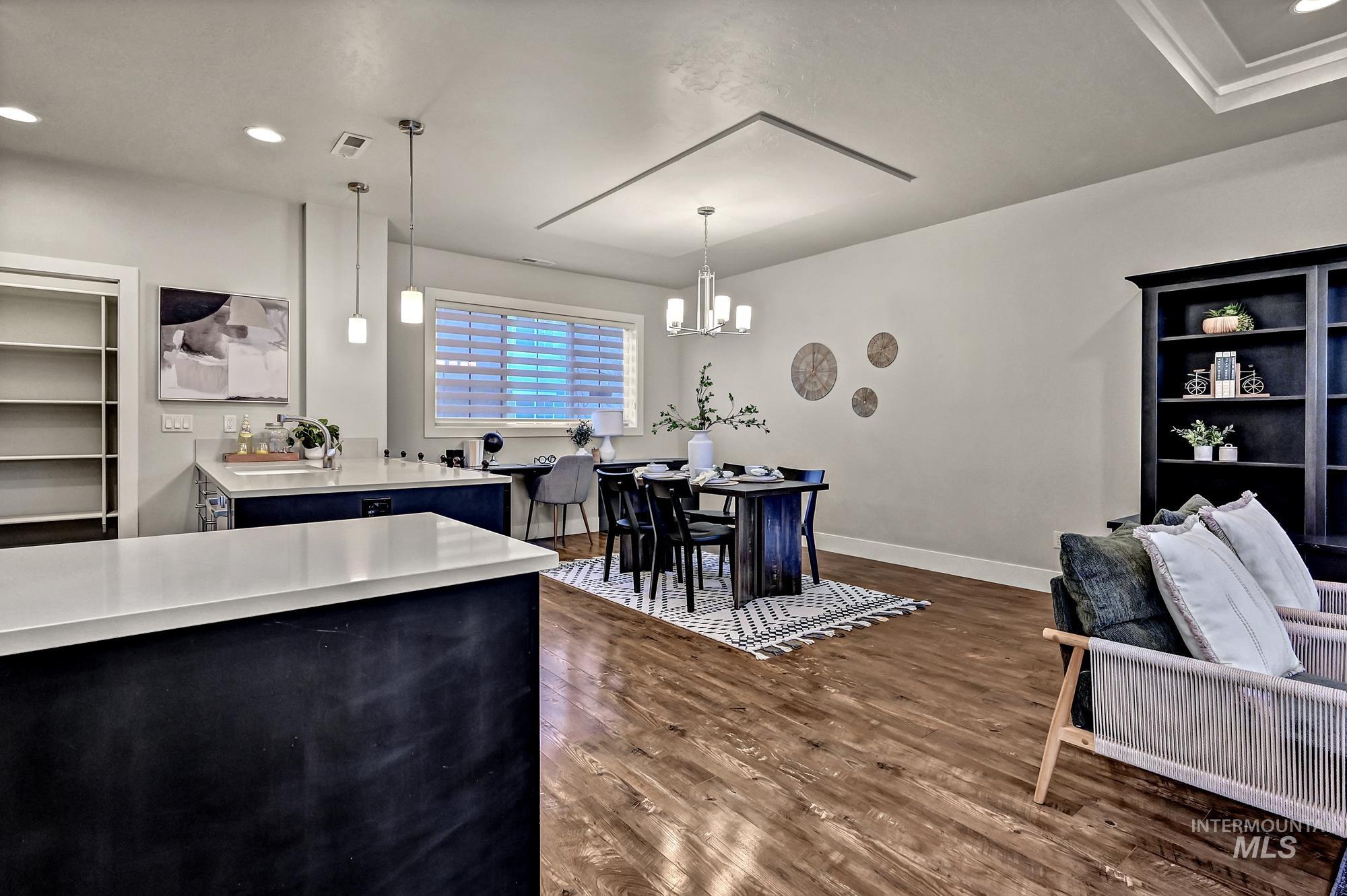 Kitchen featuring pendant lighting, recessed lighting, dark wood finished floors, and a chandelier