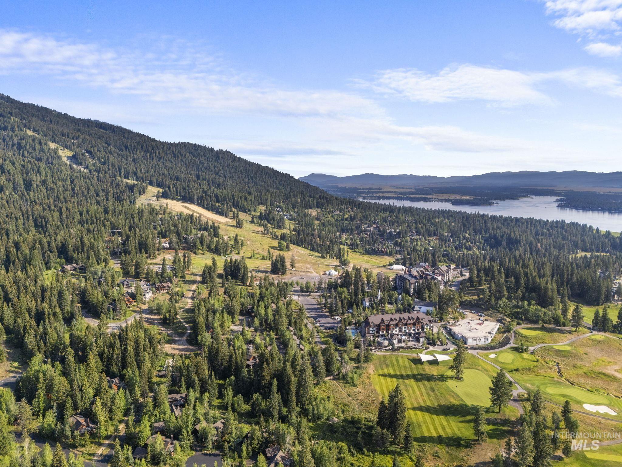 Aerial overview of property's location featuring a water and mountain view and a local golf course
