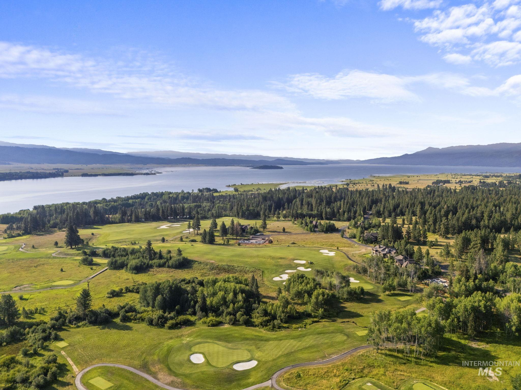 Aerial view of property's location featuring a water and mountain view and a local golf course