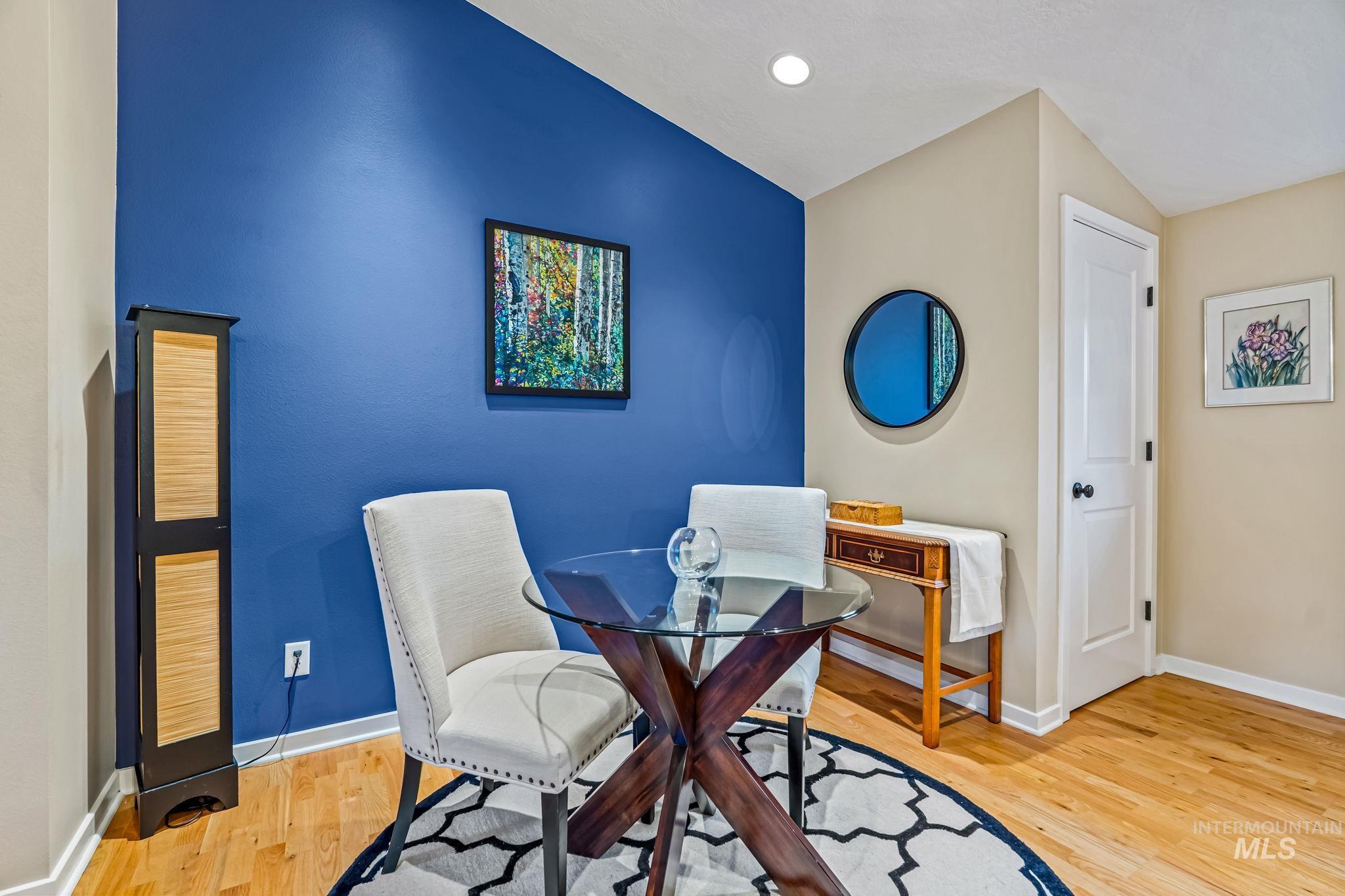 Dining room featuring light hardwood floors and vaulted ceiling