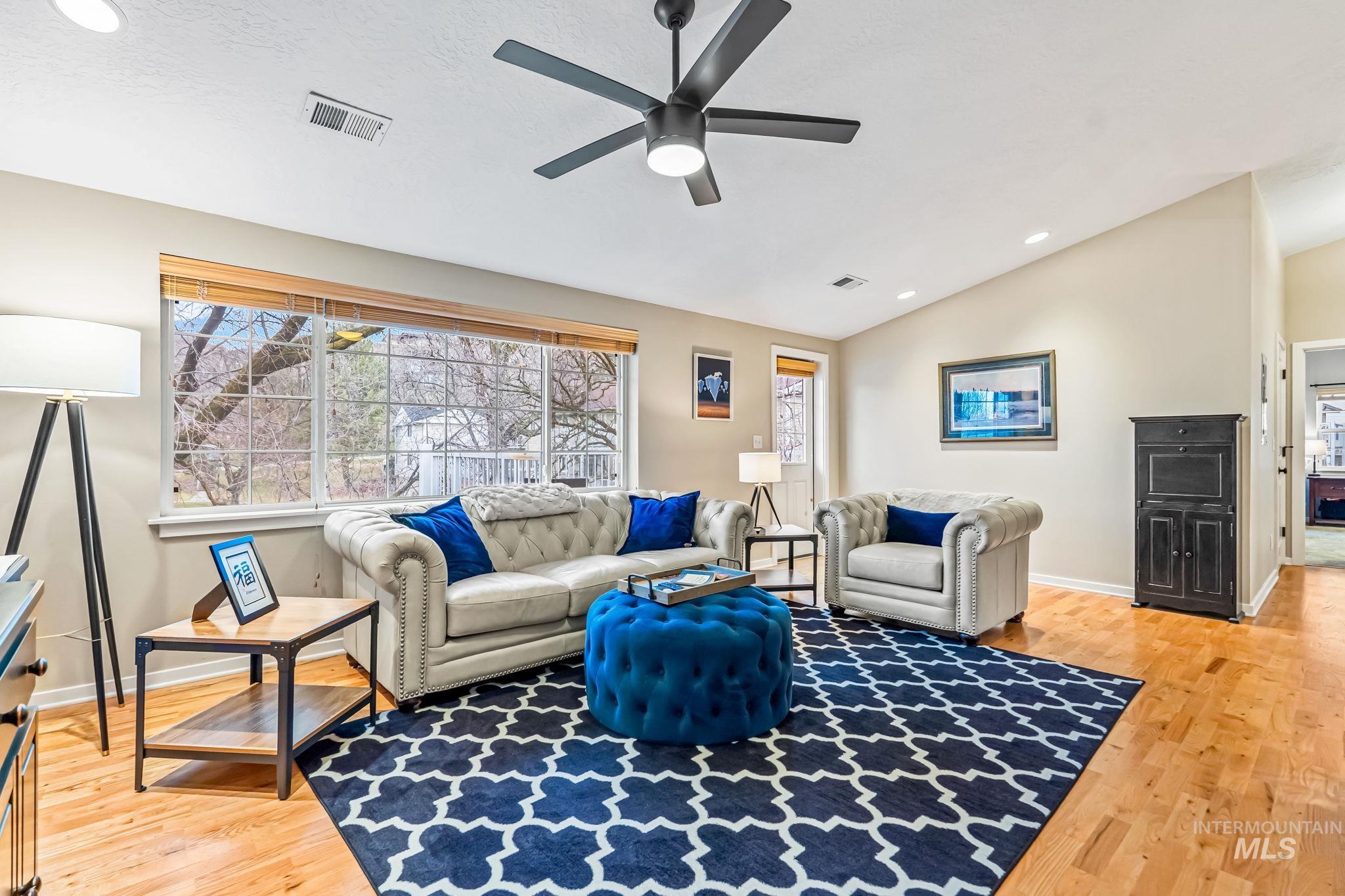 Living room featuring recessed lighting, lofted ceiling, a ceiling fan, and light hardwood flooring