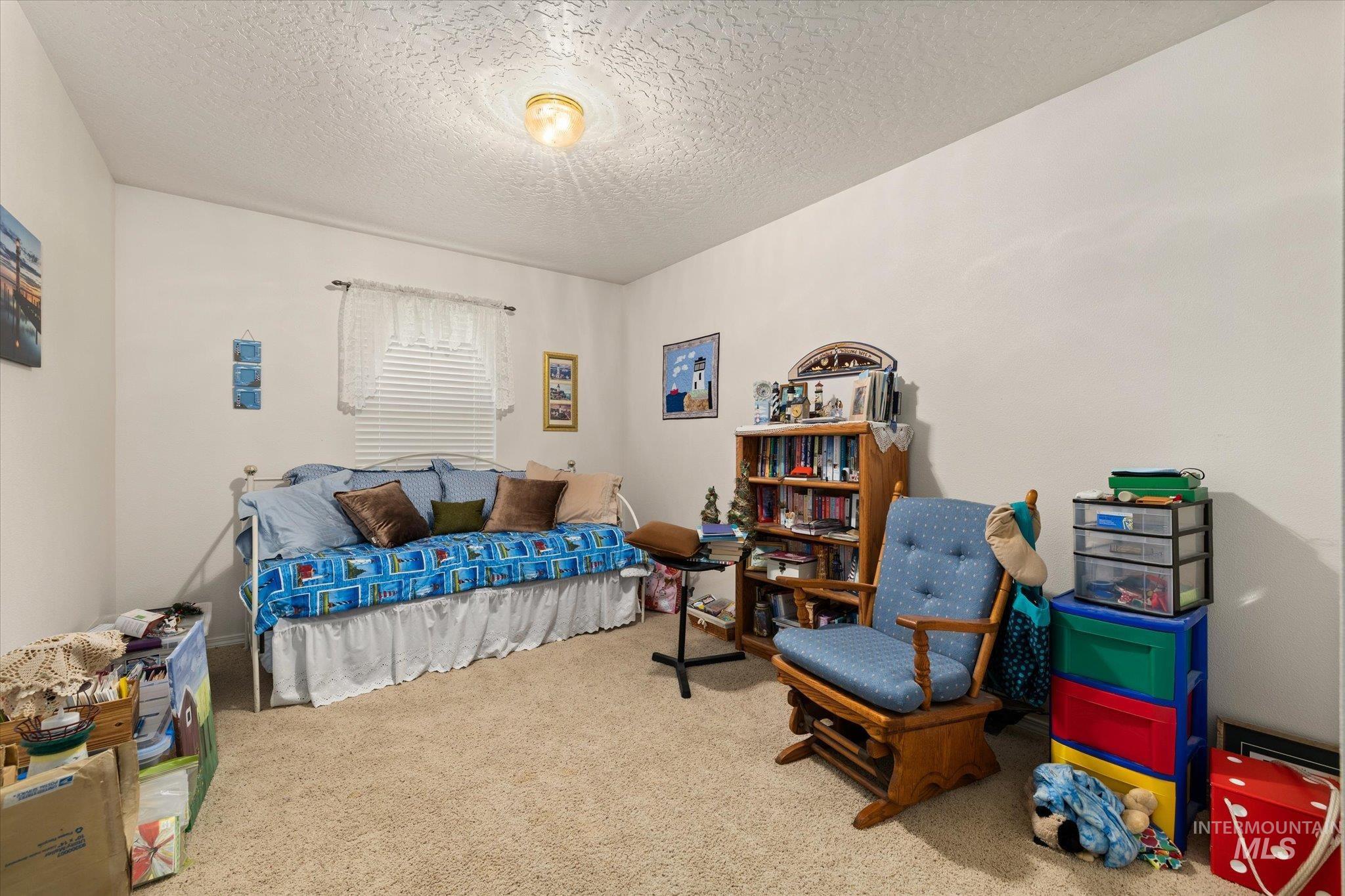 Bedroom with a textured ceiling and carpet flooring