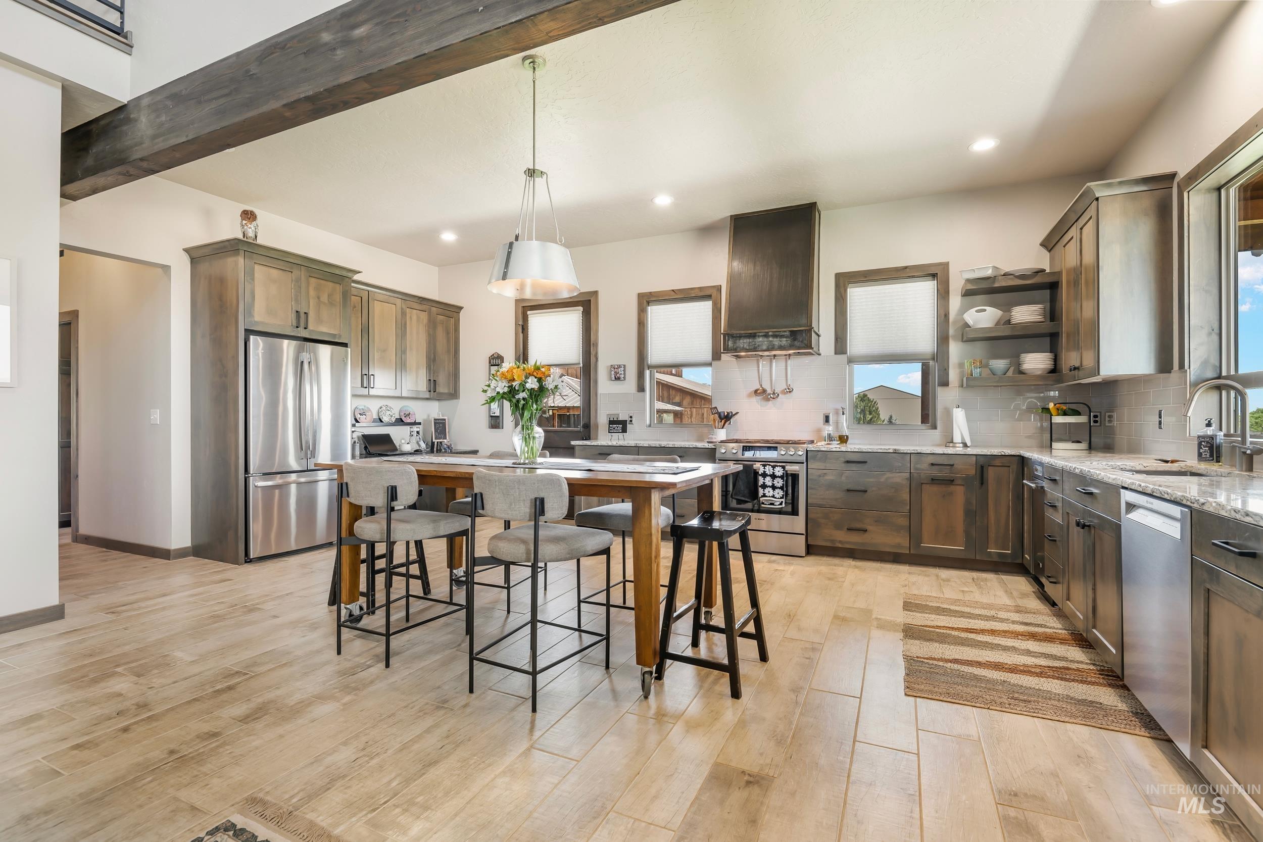 Kitchen featuring appliances with stainless steel finishes, custom exhaust hood, healthy amount of natural light, recessed lighting, and light wood finished floors