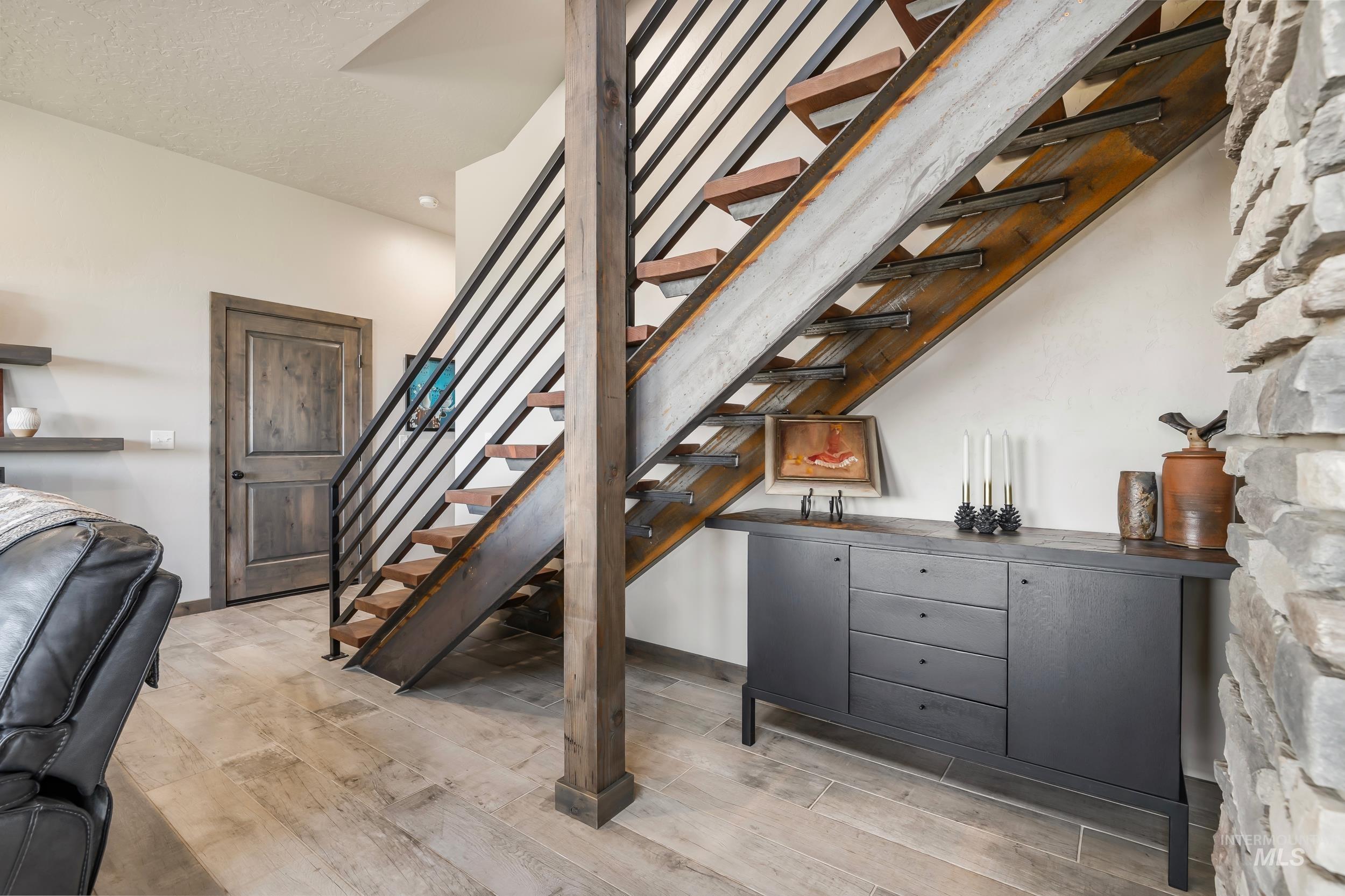 Stairway with bar area and wood finished floors