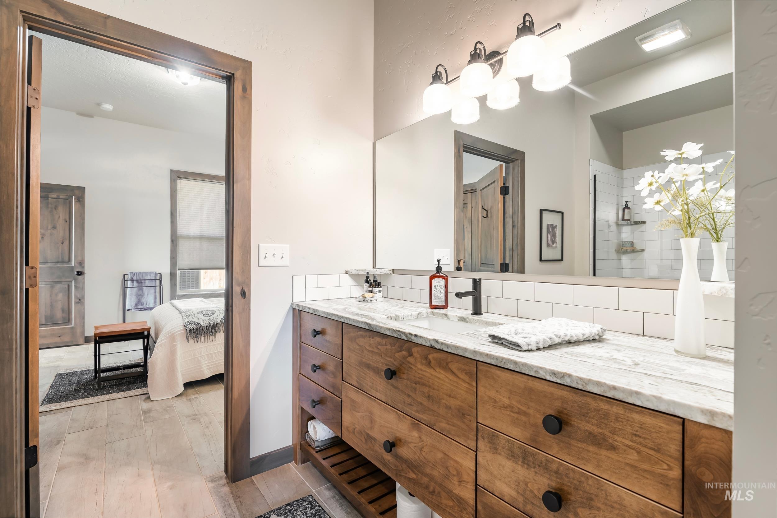 Ensuite bathroom with vanity and tasteful backsplash