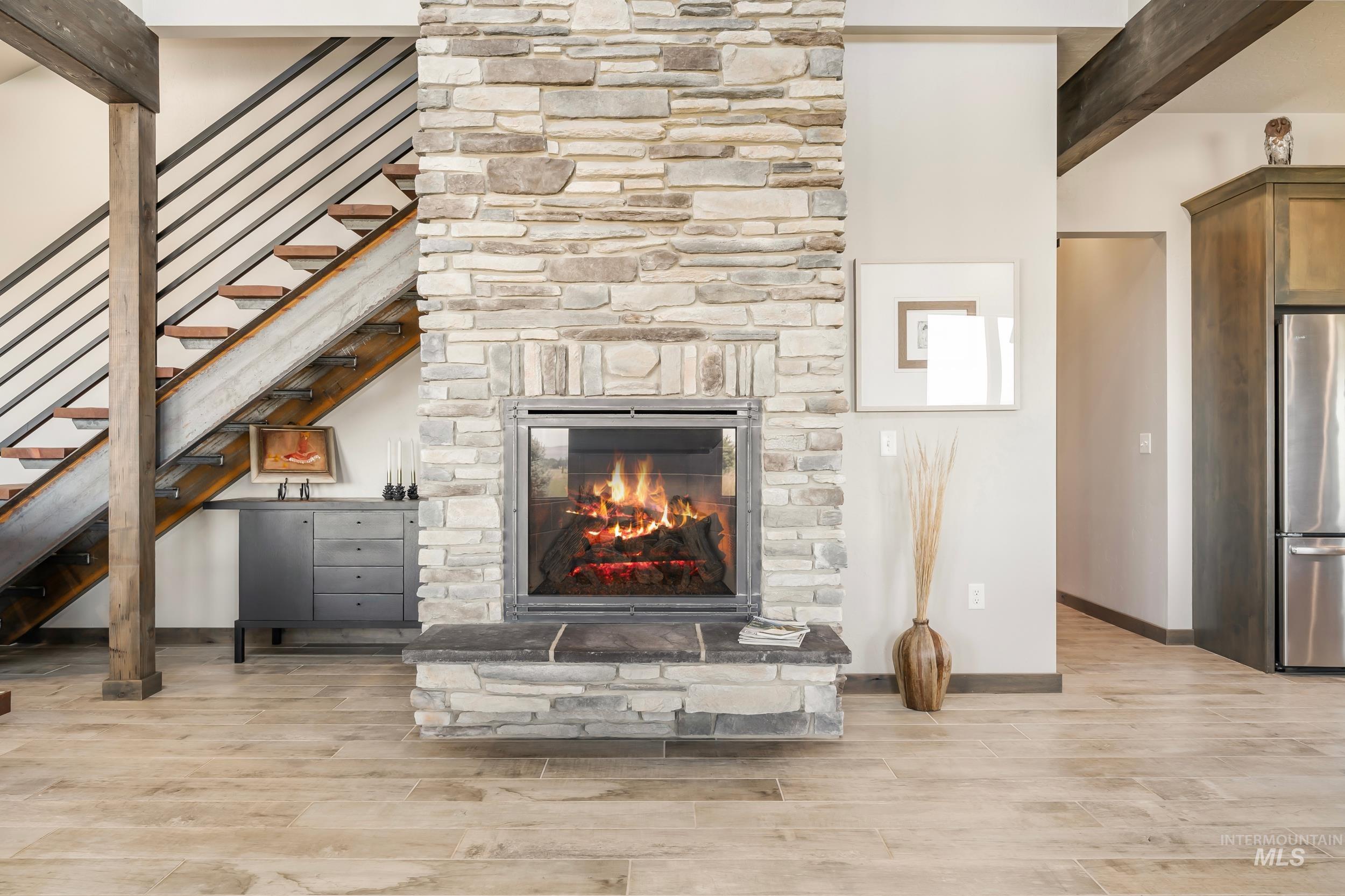 Living room featuring light wood-type flooring, a fireplace, and stairway