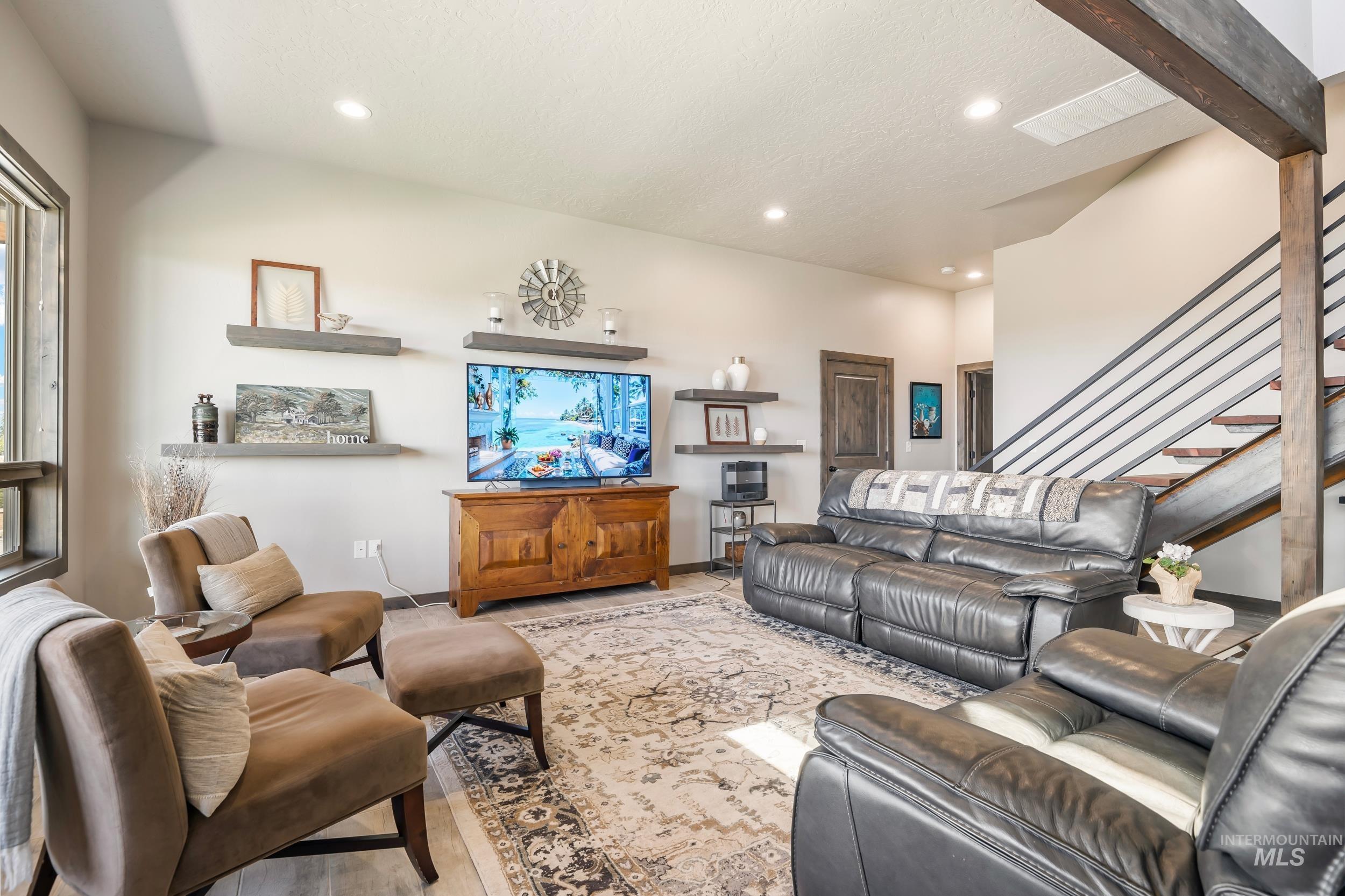 Living room with recessed lighting, stairway, and wood finished floors