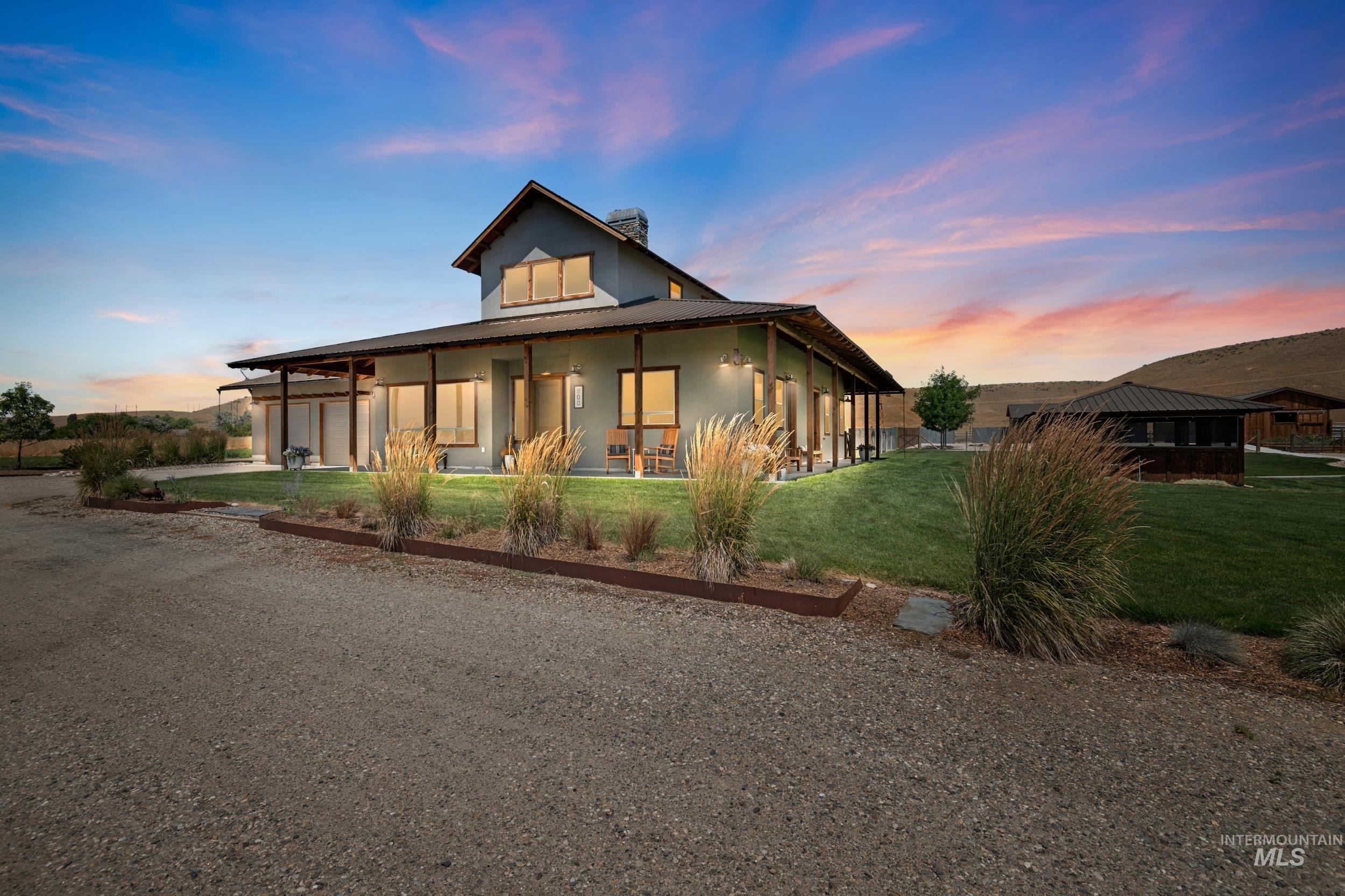 View of front of home with covered porch, stucco siding, a front lawn, a chimney, and driveway