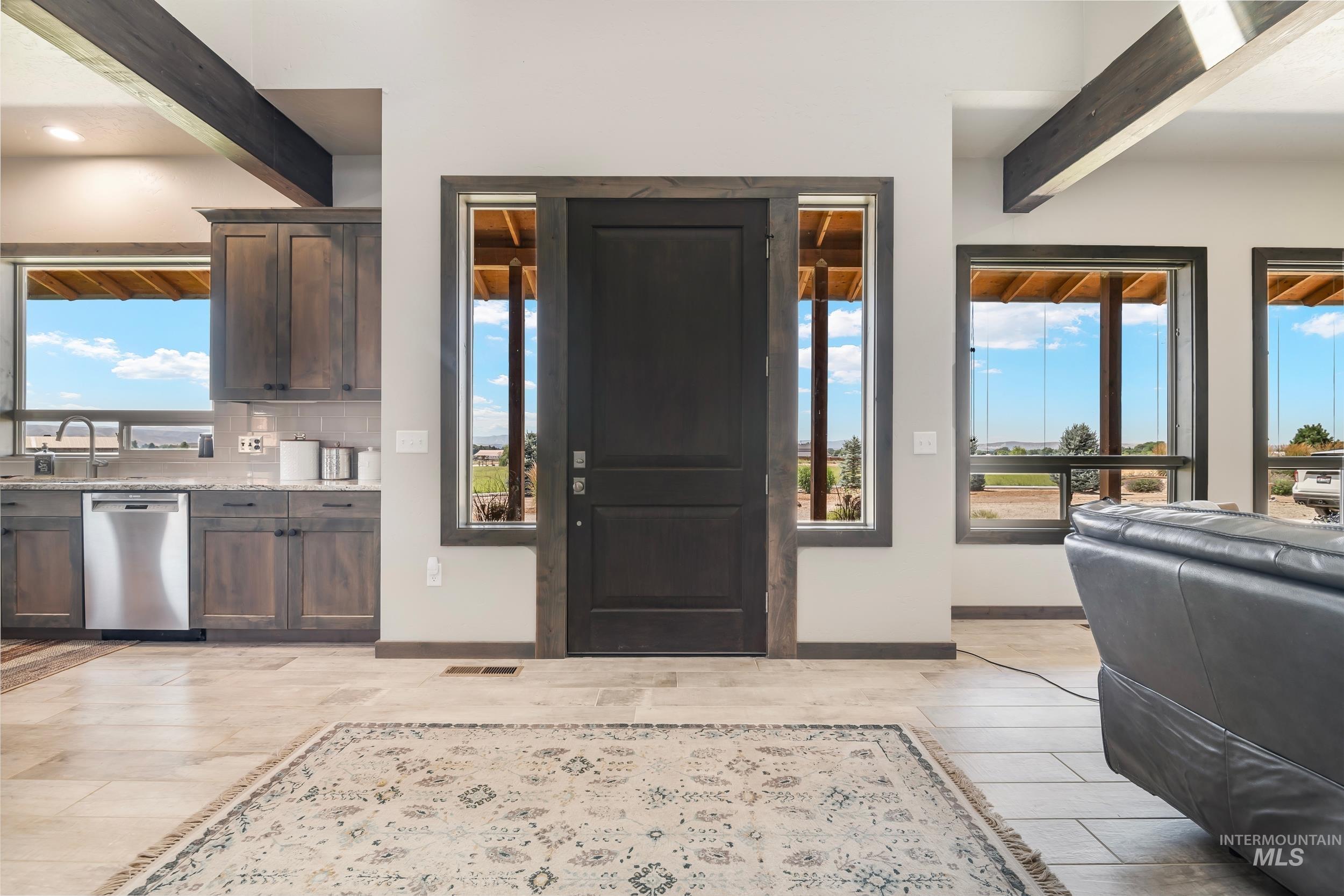 Foyer with beamed ceiling and light wood-style flooring
