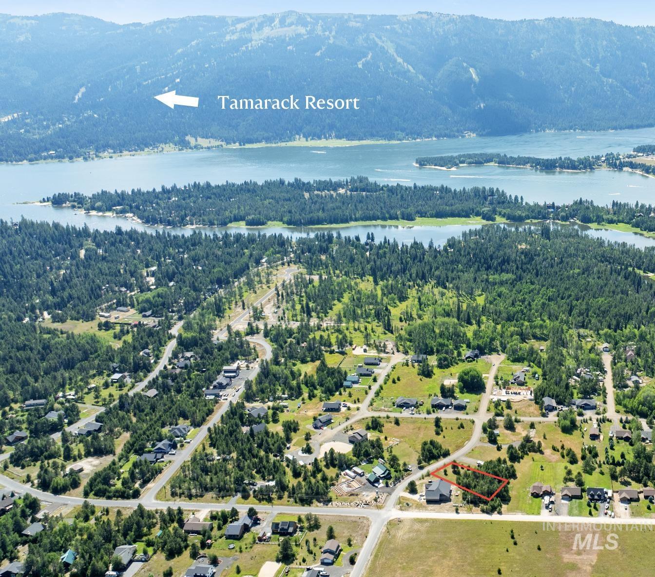 Aerial view of property and surrounding area featuring property parcel outlined and a water and mountain view