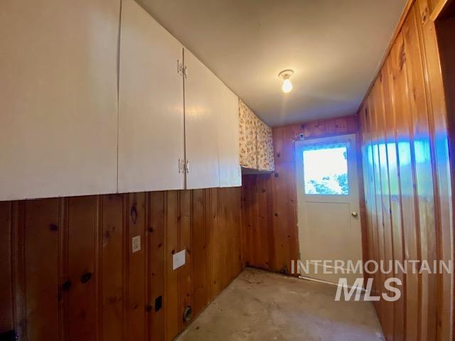 Washroom featuring wooden walls and cabinet space