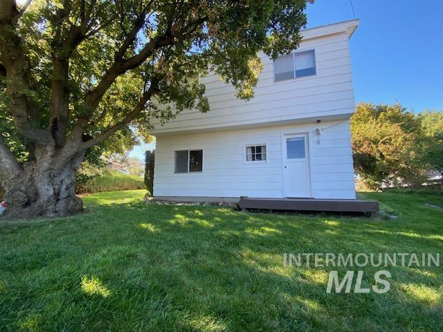 Rear view of property with a yard and a wooden deck