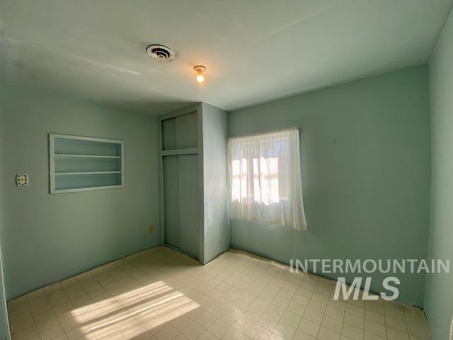 Unfurnished bedroom with a closet and light flooring