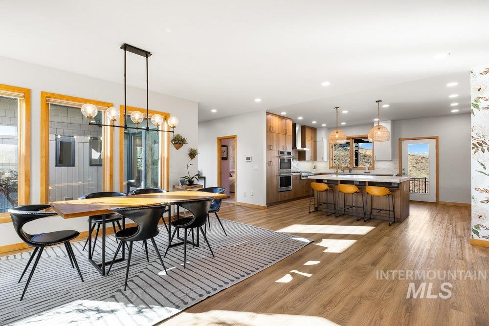 Dining space with light wood-type flooring, a chandelier, and recessed lighting