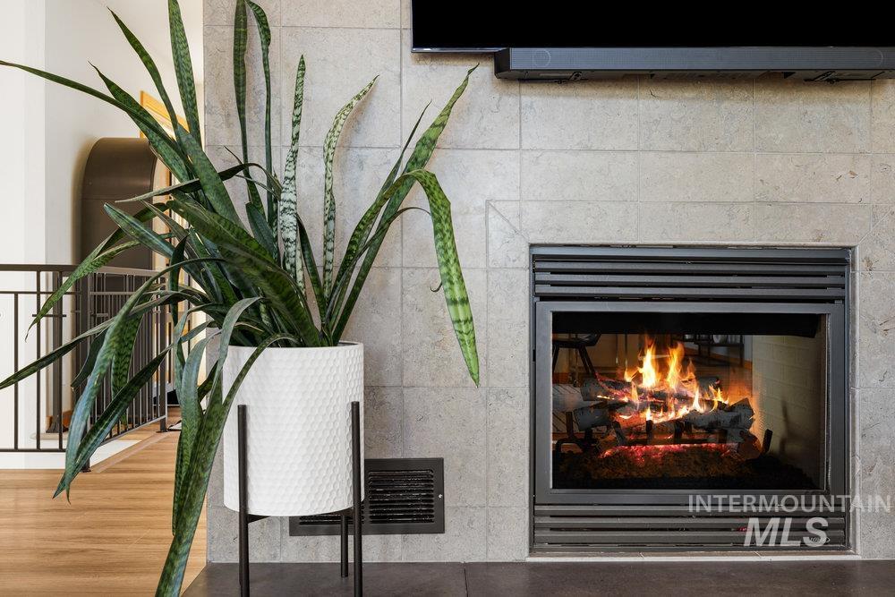Detailed view of a glass covered fireplace and wood finished floors