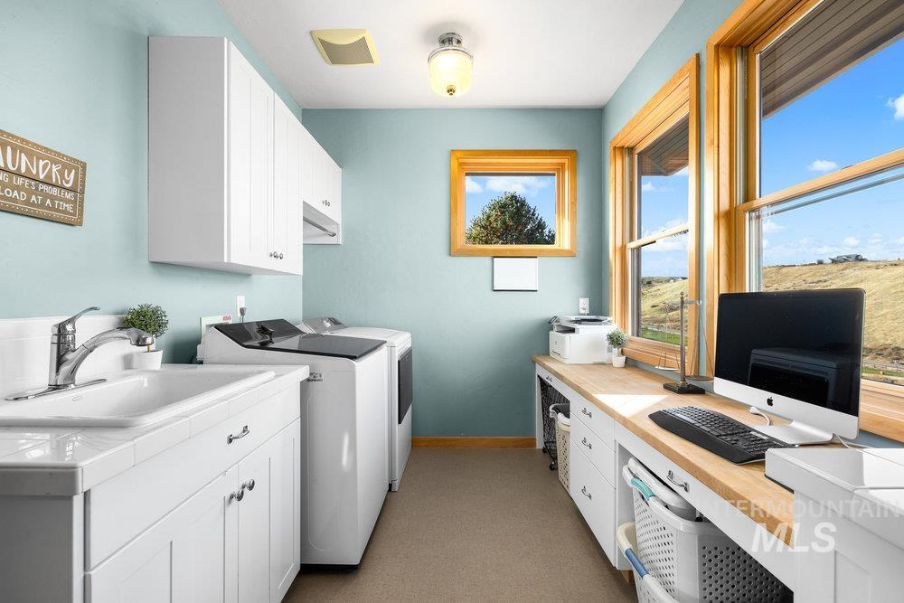 Laundry area with washing machine and dryer, cabinet space, and an office area