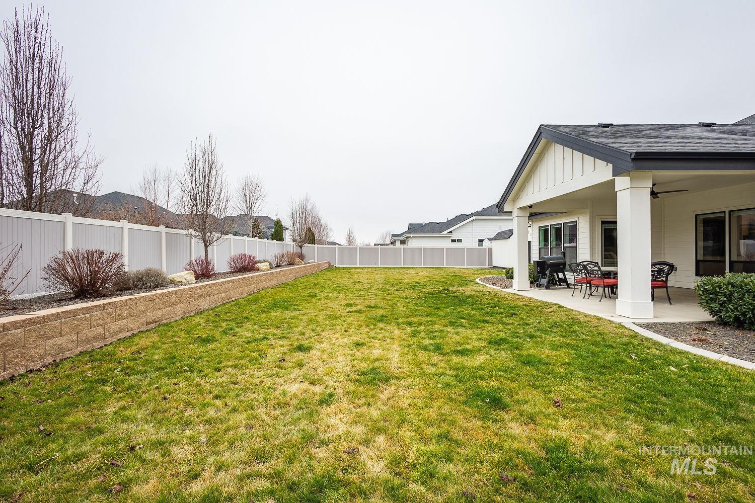 Fenced backyard with a patio and ceiling fan