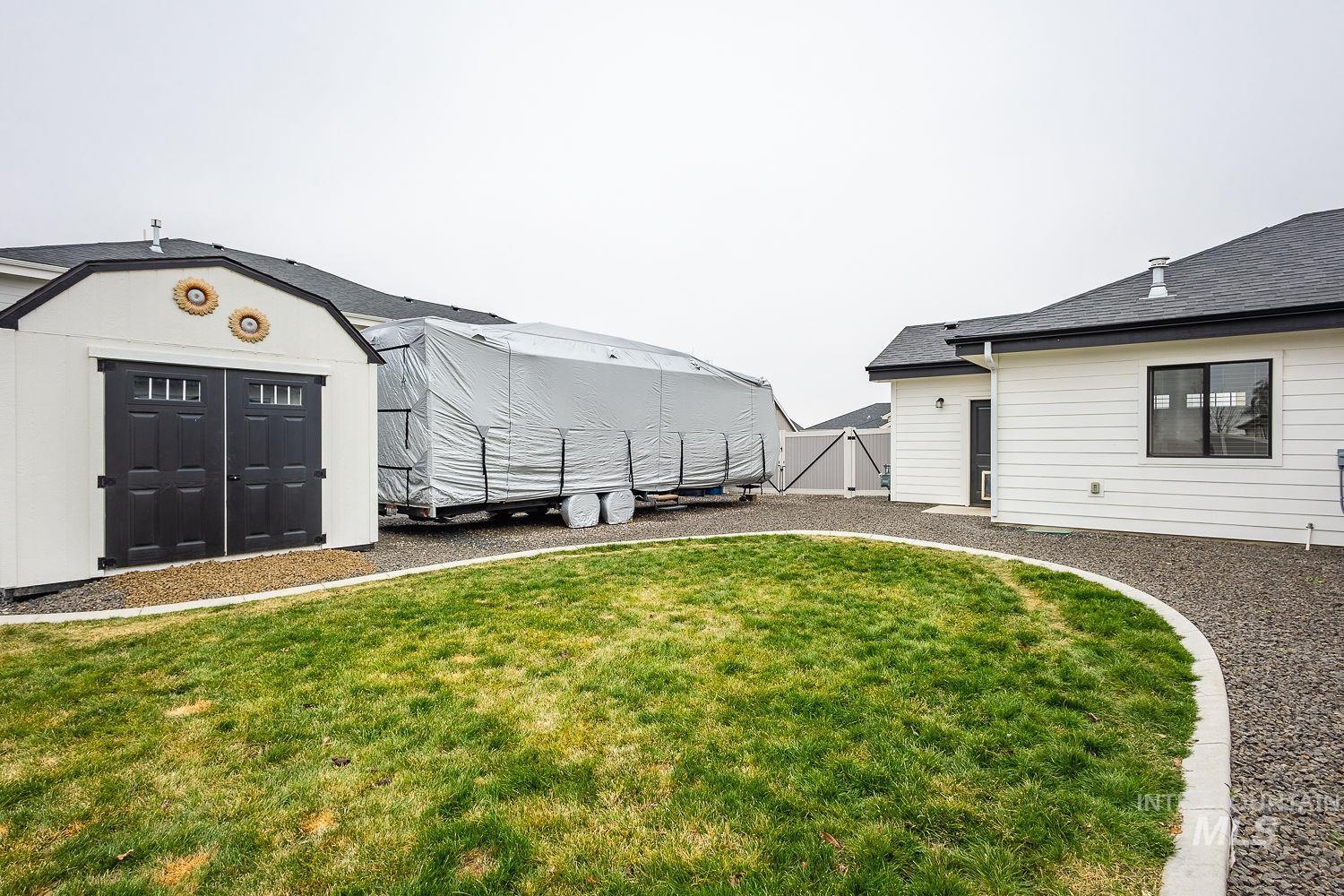 View of green lawn featuring a storage shed