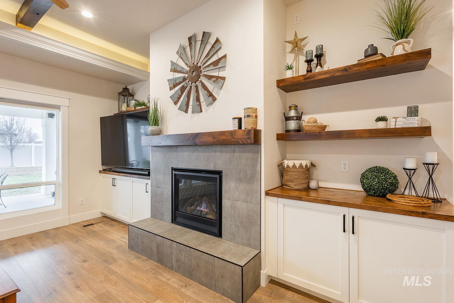 Living room with a tile fireplace and light wood finished floors