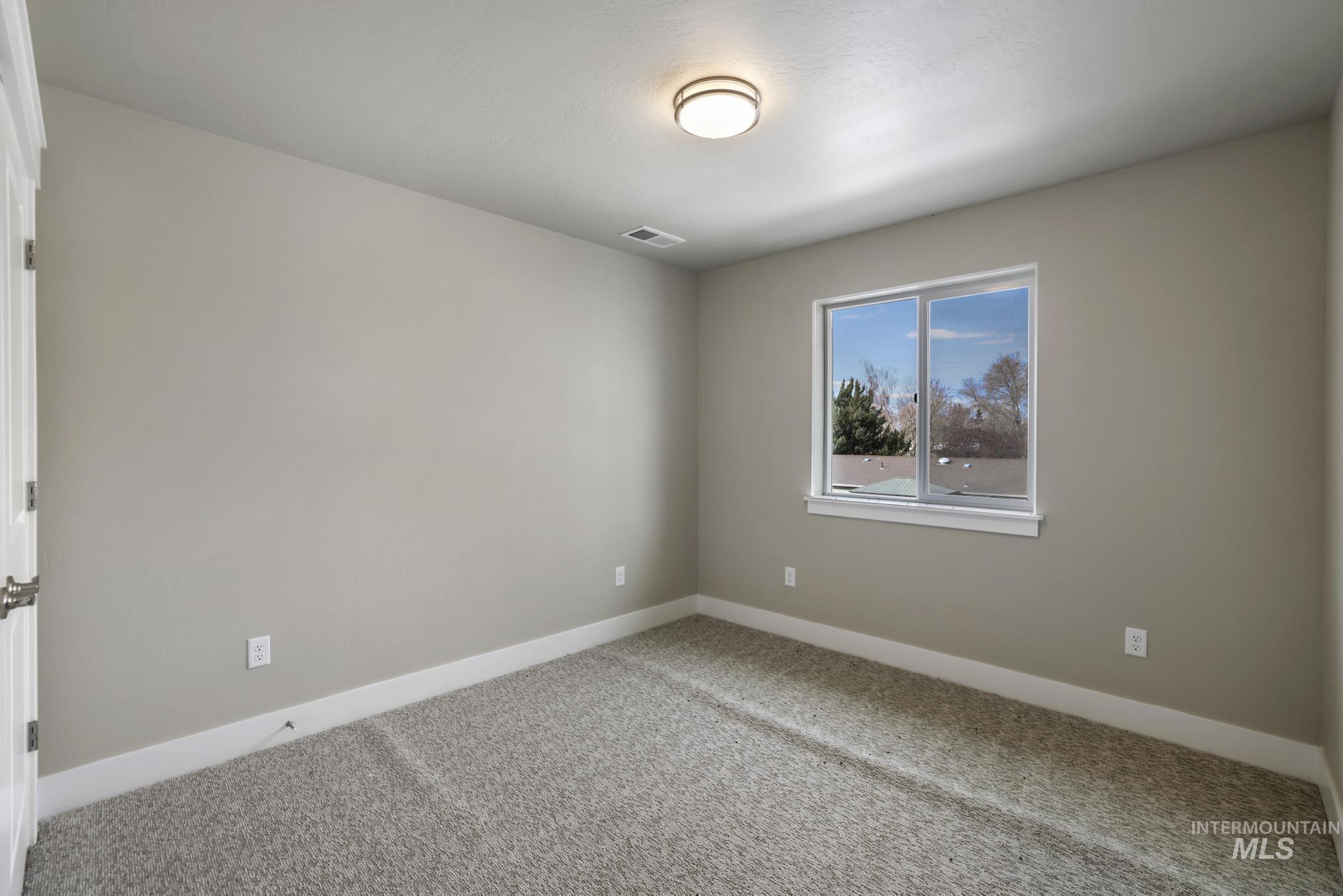 Carpeted spare room with baseboards