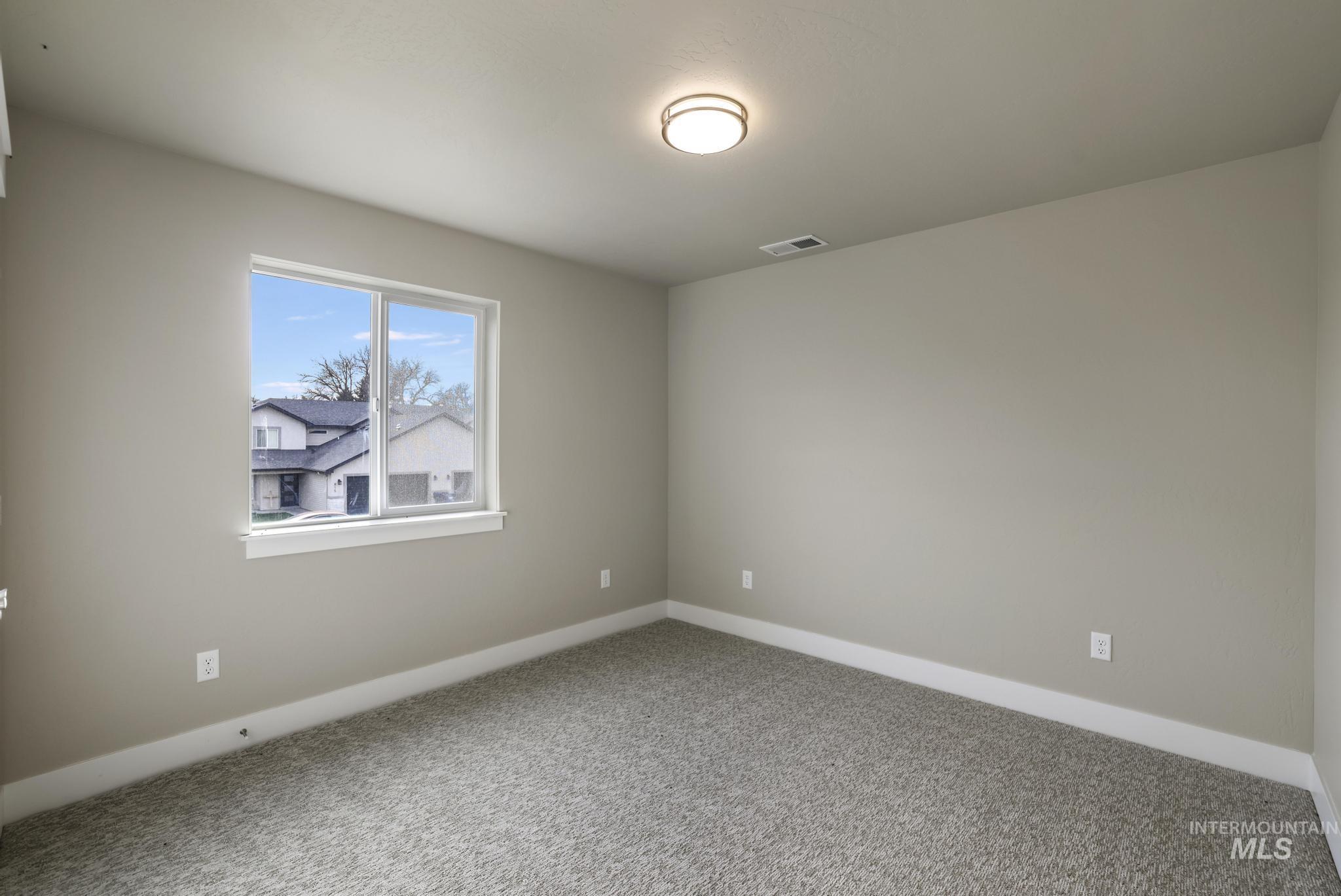 Carpeted spare room with baseboards