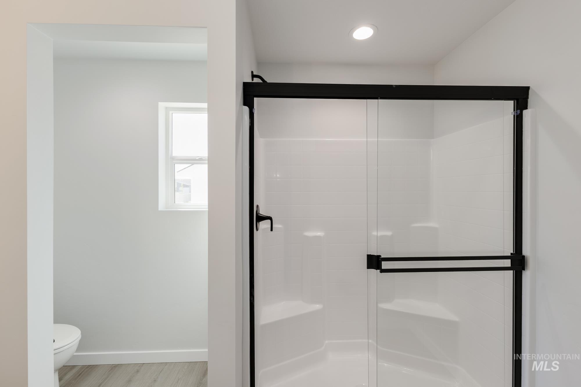 Bathroom featuring a shower stall, recessed lighting, and light wood-style flooring