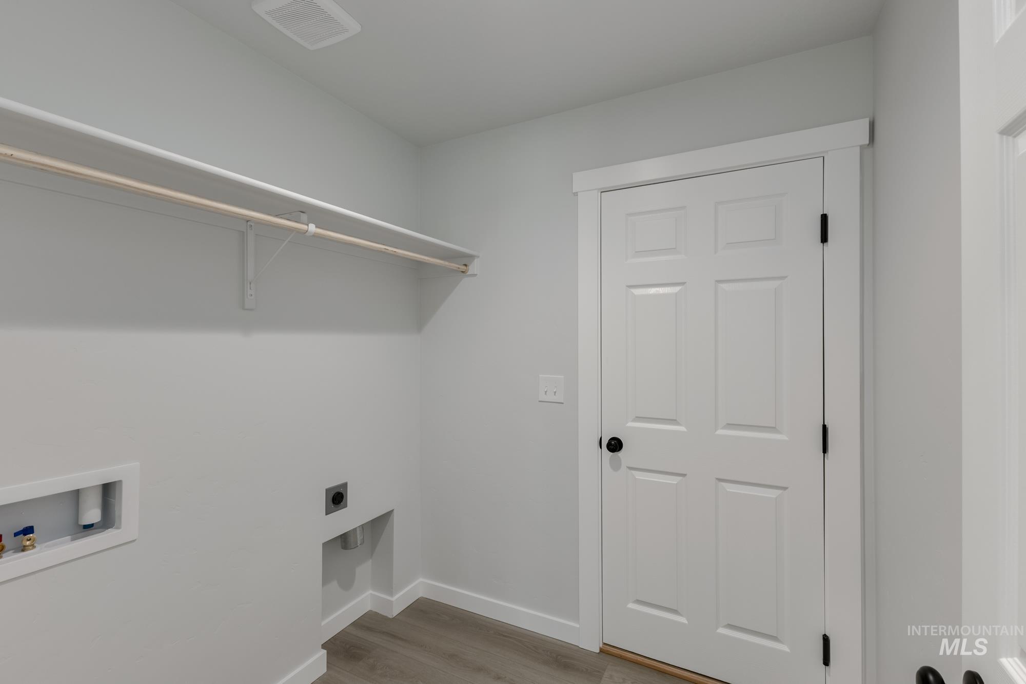 Laundry area featuring light wood finished floors, hookup for a washing machine, and hookup for an electric dryer